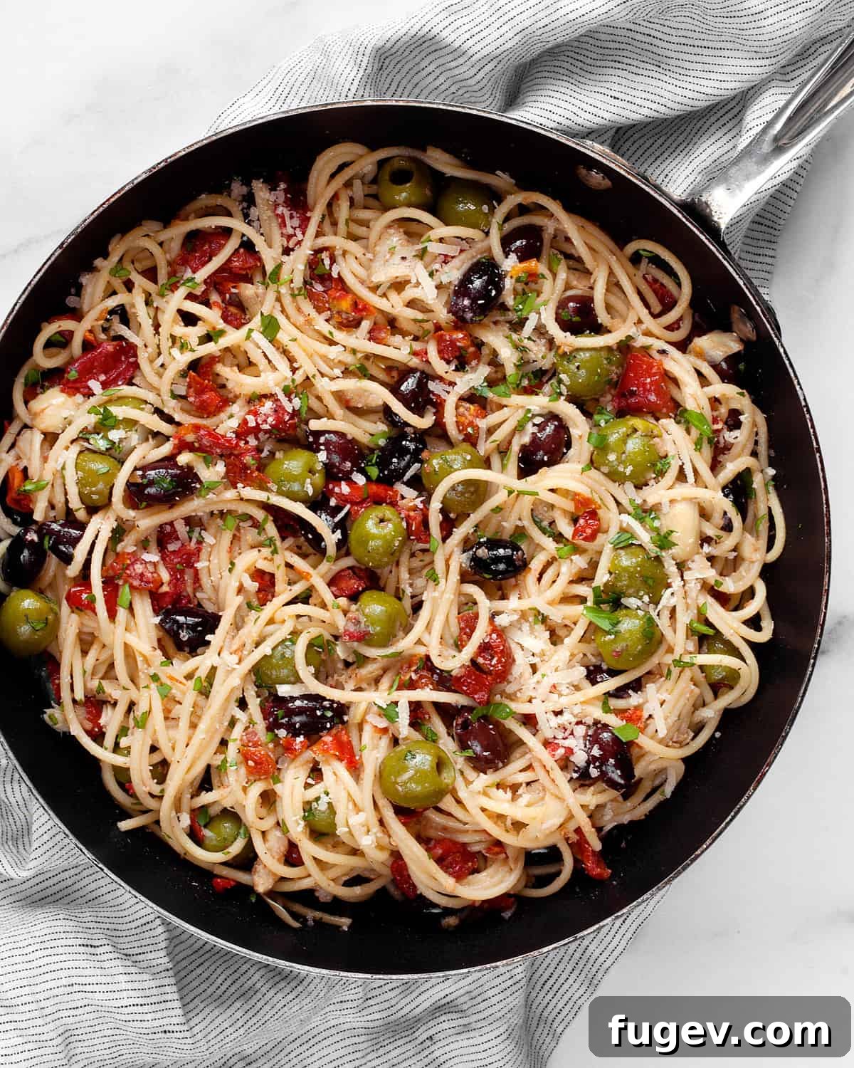 Antipasto Platter Pasta 6 Spaghetti expertly tossed in a skillet with a colorful assortment of antipasti, ready to be served.