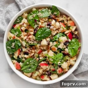 Vibrant Quinoa Salad with Apples Walnuts Cranberries and Fresh Spinach 7 Apple salad with quinoa and baby spinach in a bowl.