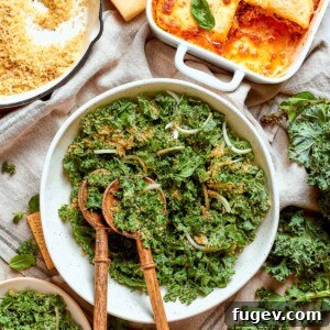 Tuscan kale salad served with elegant wooden spoons, generously topped with Parmesan and golden breadcrumb crunchies.