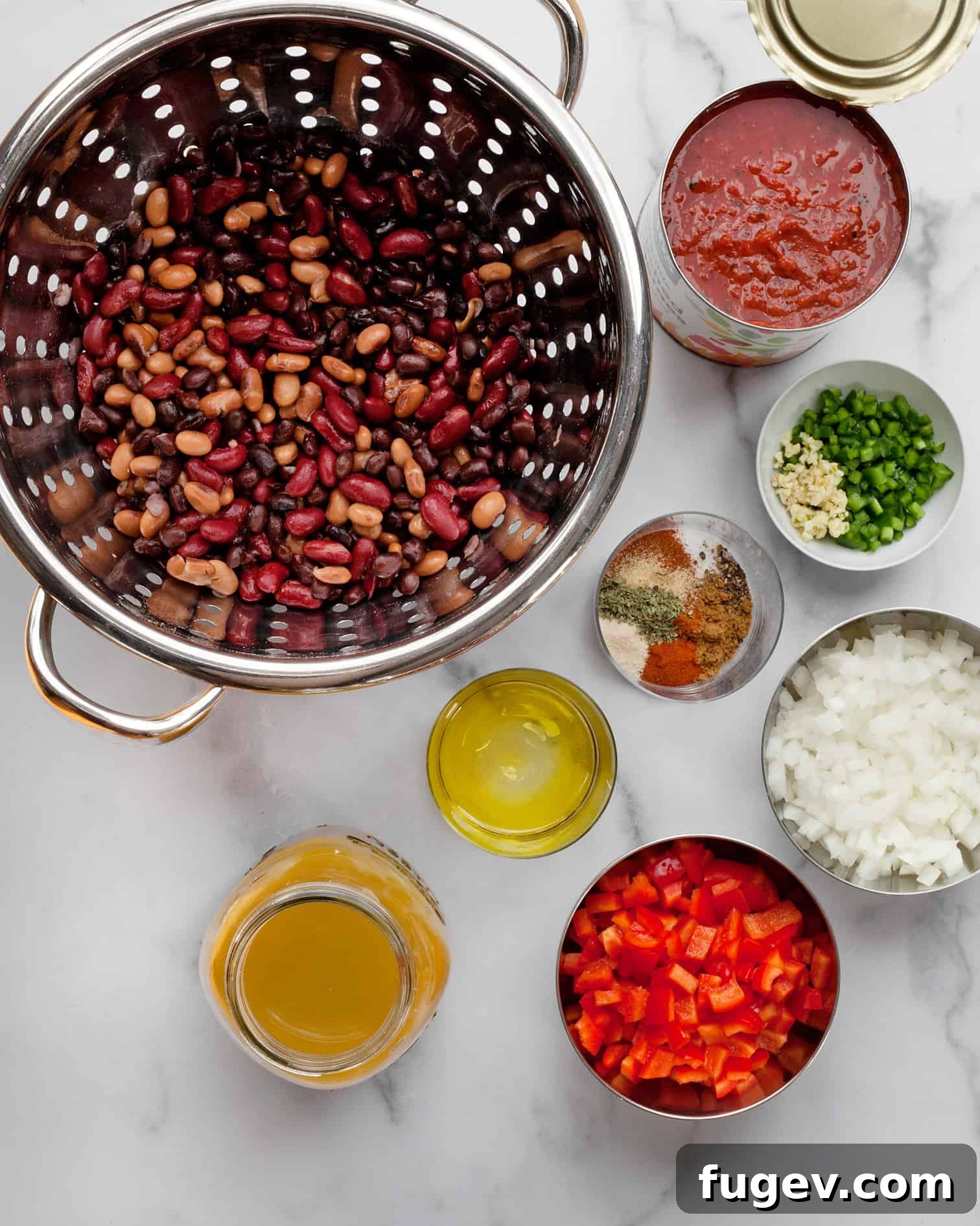 Hearty Bean Chili Delight 3 Ingredients for three-bean chili including various beans, canned tomatoes, bell peppers, fresh jalapenos, garlic, and an array of dried spices.