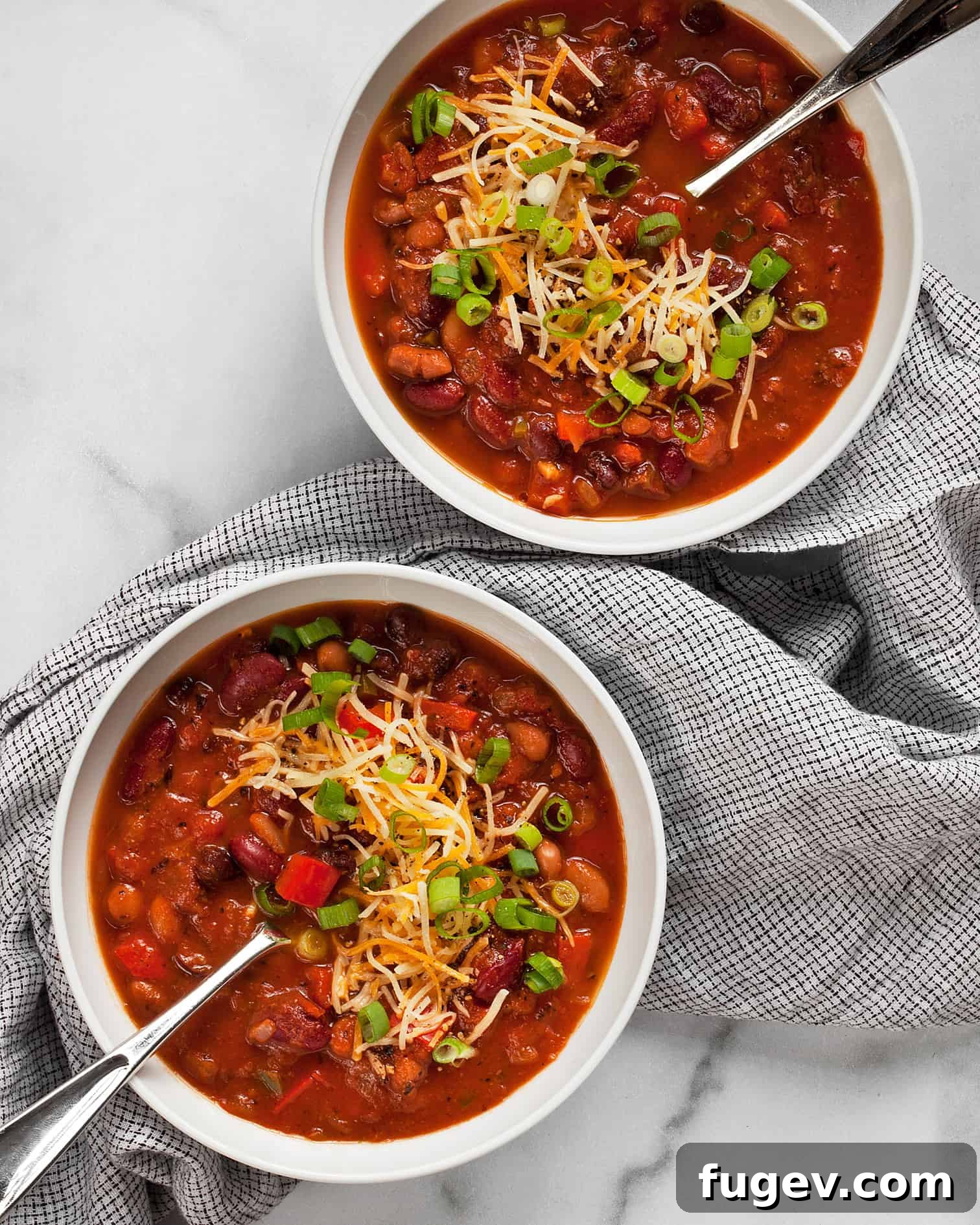 Hearty Bean Chili Delight 6 Two vibrant bowls of three-bean chili, richly garnished and ready to be served.
