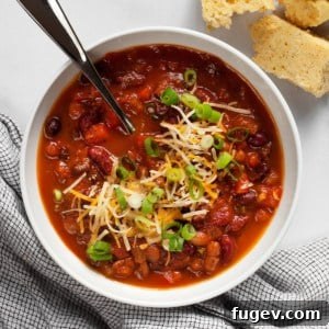 Three bean chili in a bowl with cornbread on the side.