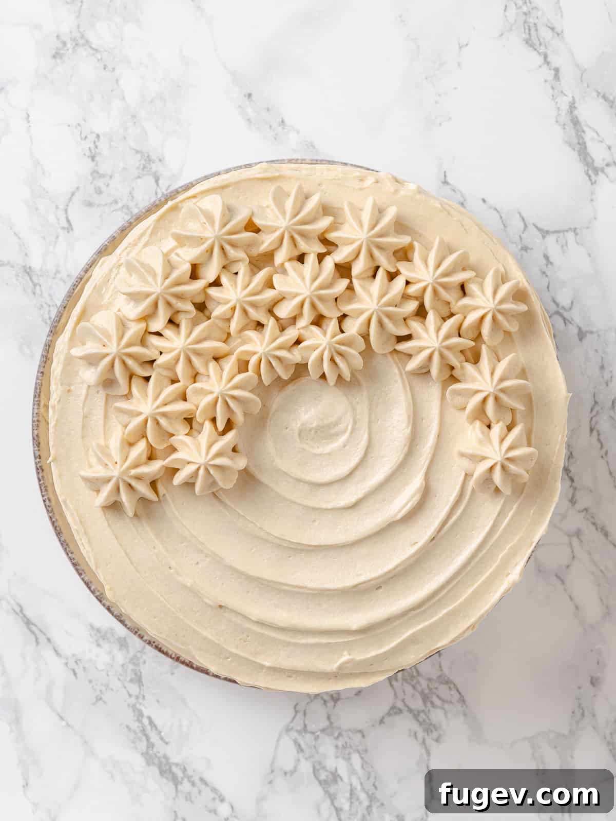 Golden Maple Delight 13 Thick swirls of creamy maple frosting generously applied to the surface of a cake, showcasing its rich texture.
