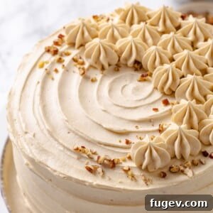 A slice of maple cake adorned with toasted pecans, showcasing the frosting.