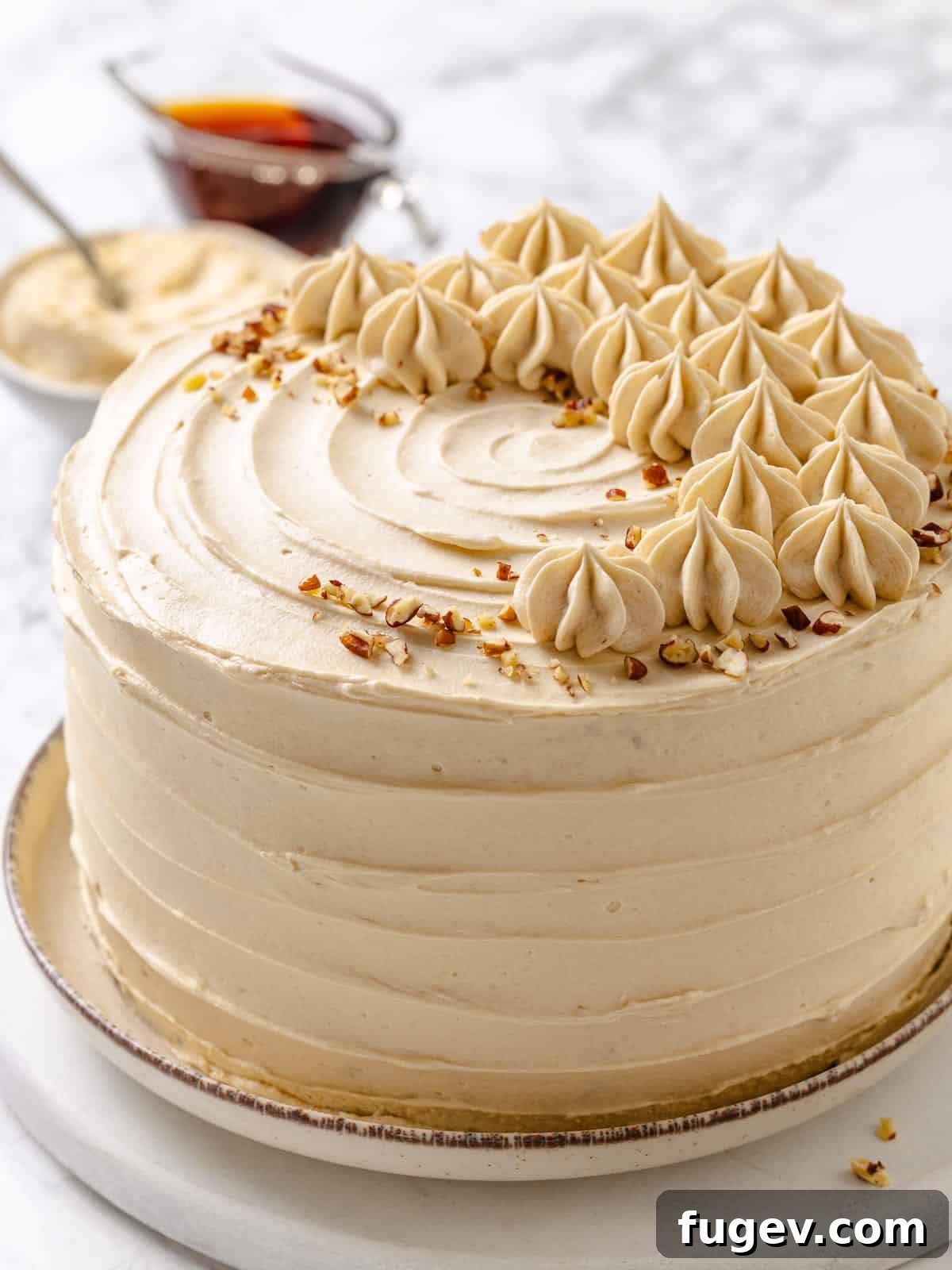 Golden Maple Temptation 20 A beautiful slice of maple cake resting on a white plate, showcasing fluffy frosting between tender layers.