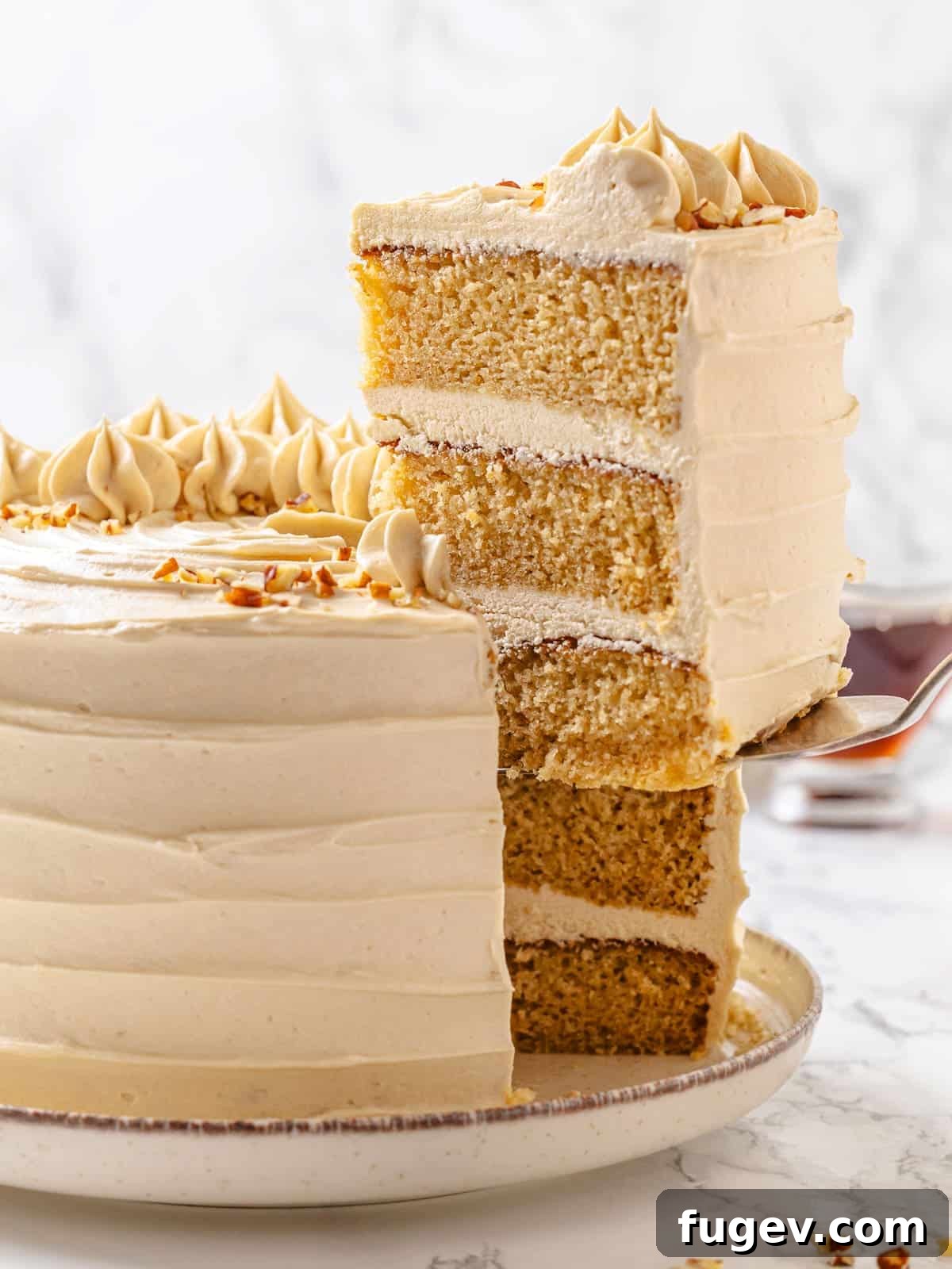 Golden Maple Temptation 21 A slice of maple cake being served, showing creamy frosting between soft cake layers on a serving utensil.