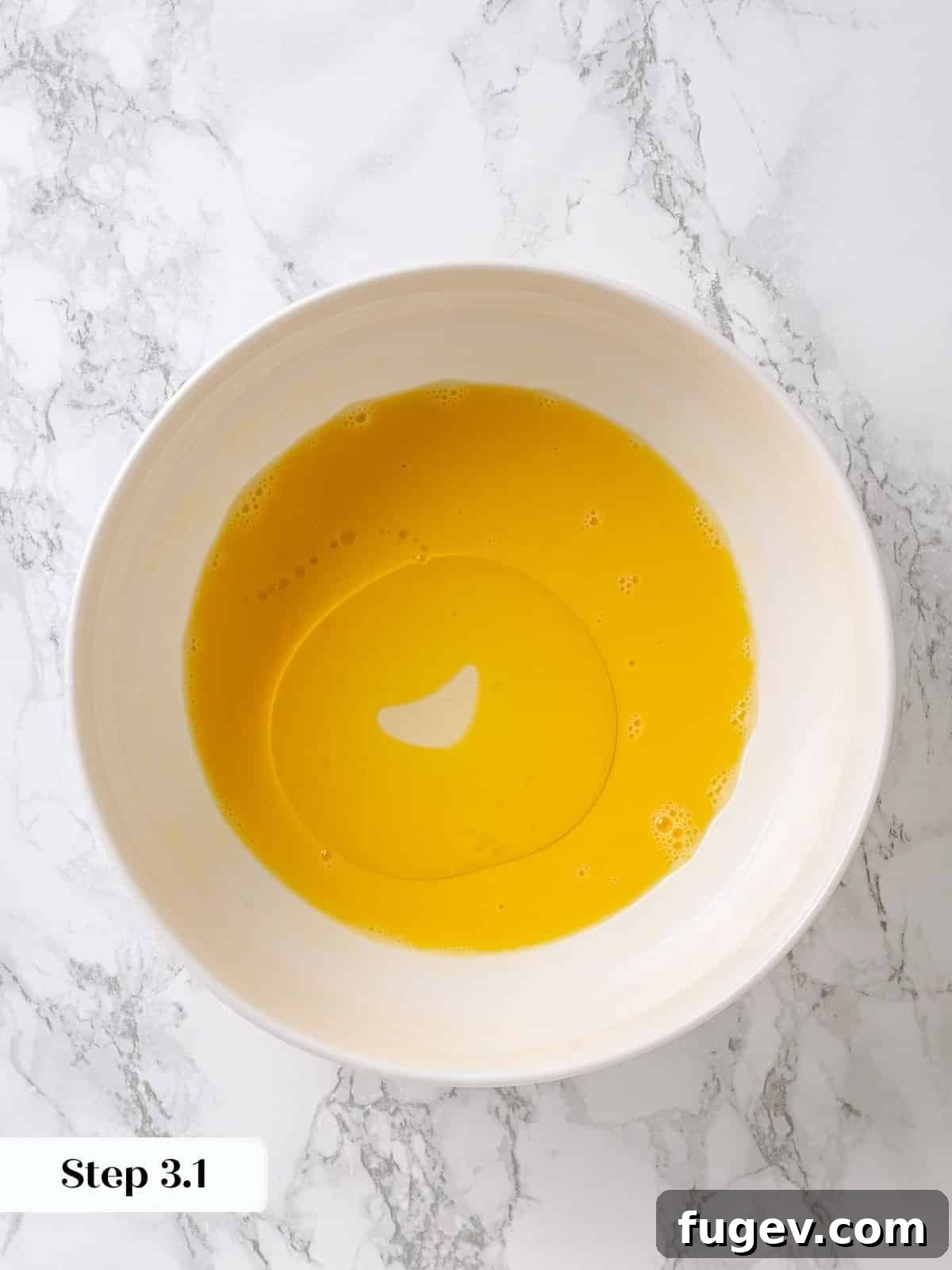 Golden Maple Temptation 6 Neutral oil being poured slowly into whisked eggs to create an emulsion for the cake batter.