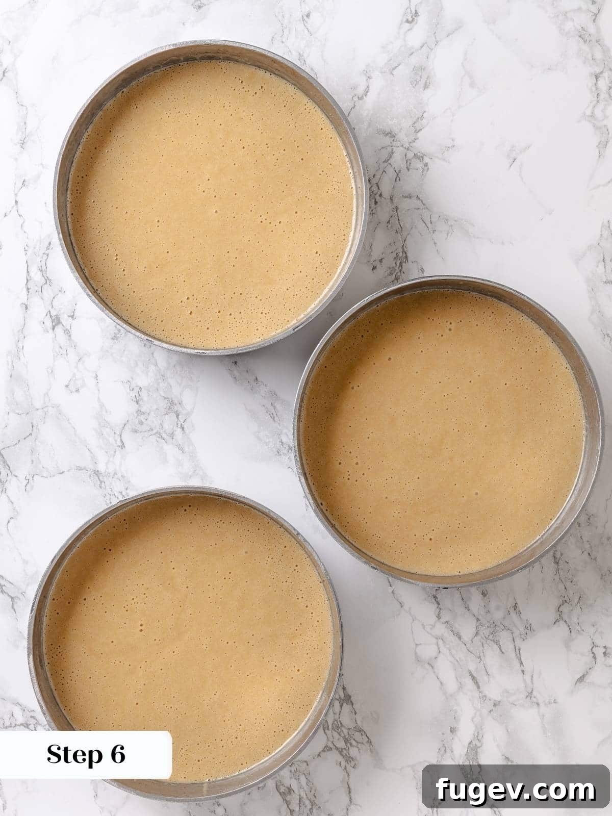 Golden Maple Temptation 10 Smooth maple cake batter poured evenly into round cake pans, ready for baking.