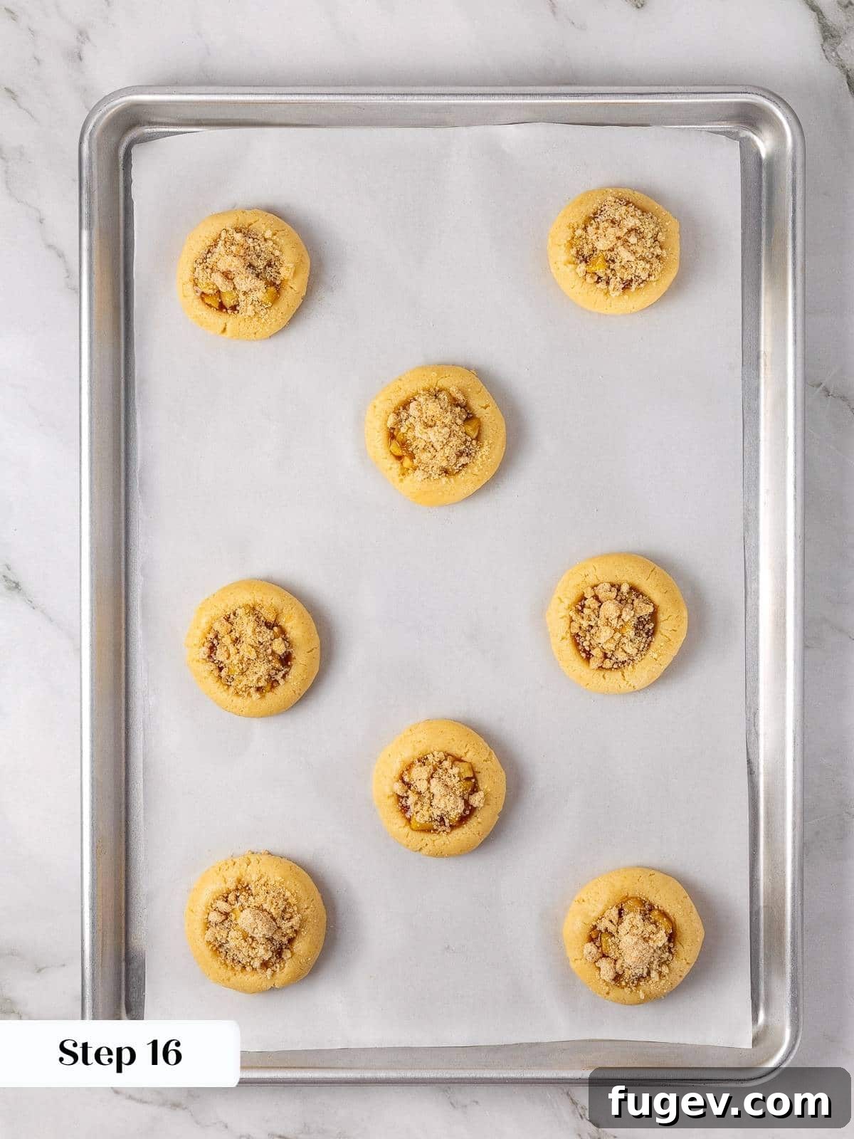 Warm Apple Spice Cookies 14 Unbaked apple pie cookies, now beautifully topped with a generous layer of brown sugar crumble, awaiting their delicious transformation in the oven.