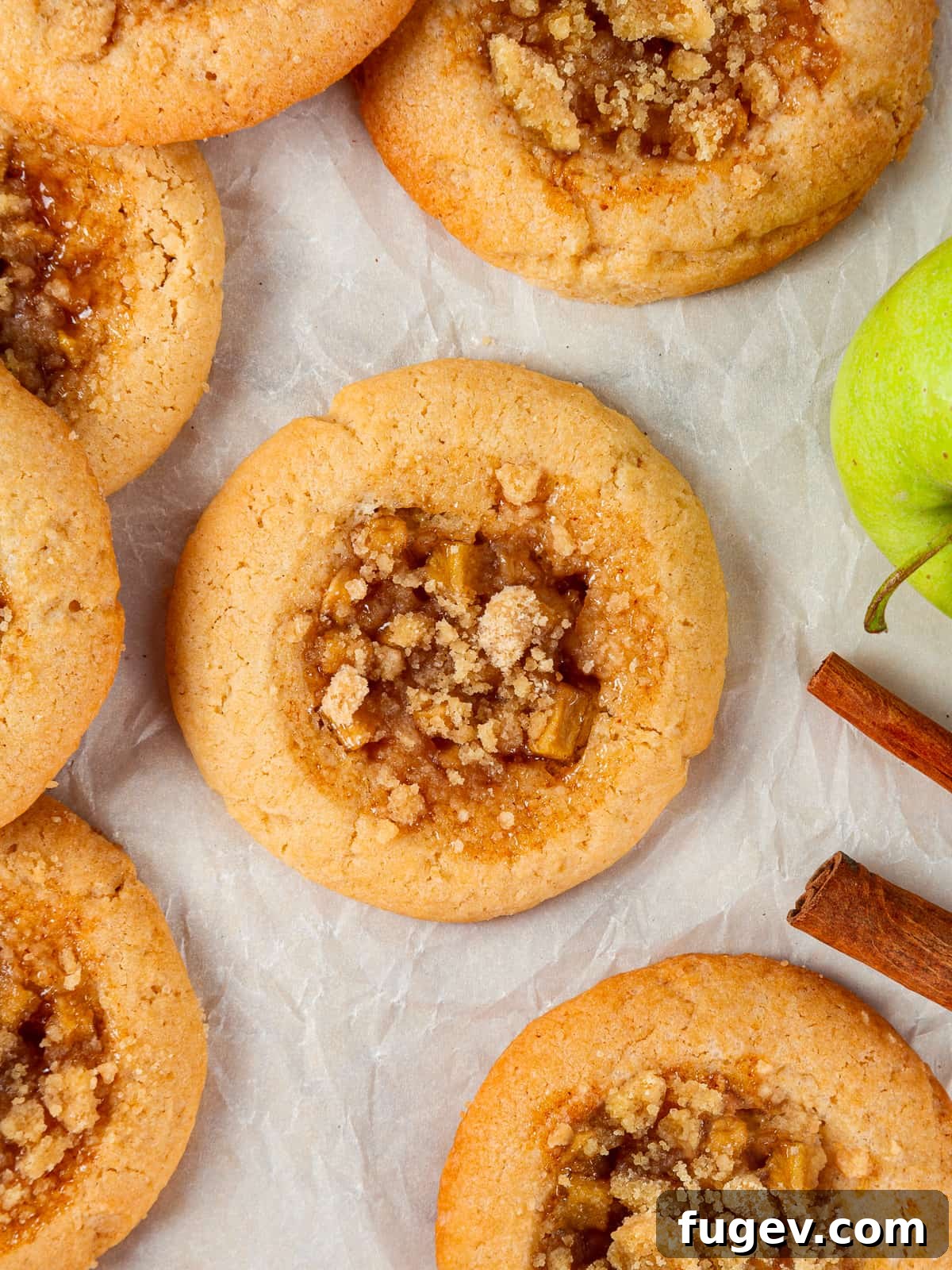 Warm Apple Spice Cookies 16 A close-up of baked apple cookies, showcasing the delightful golden crumble and caramelized apple filling, still perfectly arranged on the parchment sheet.
