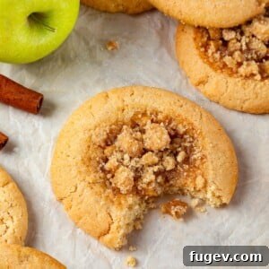 Warm Apple Spice Cookies 18 A single apple pie cookie with a bite taken out, revealing its chewy brown sugar dough and delectable apple filling.