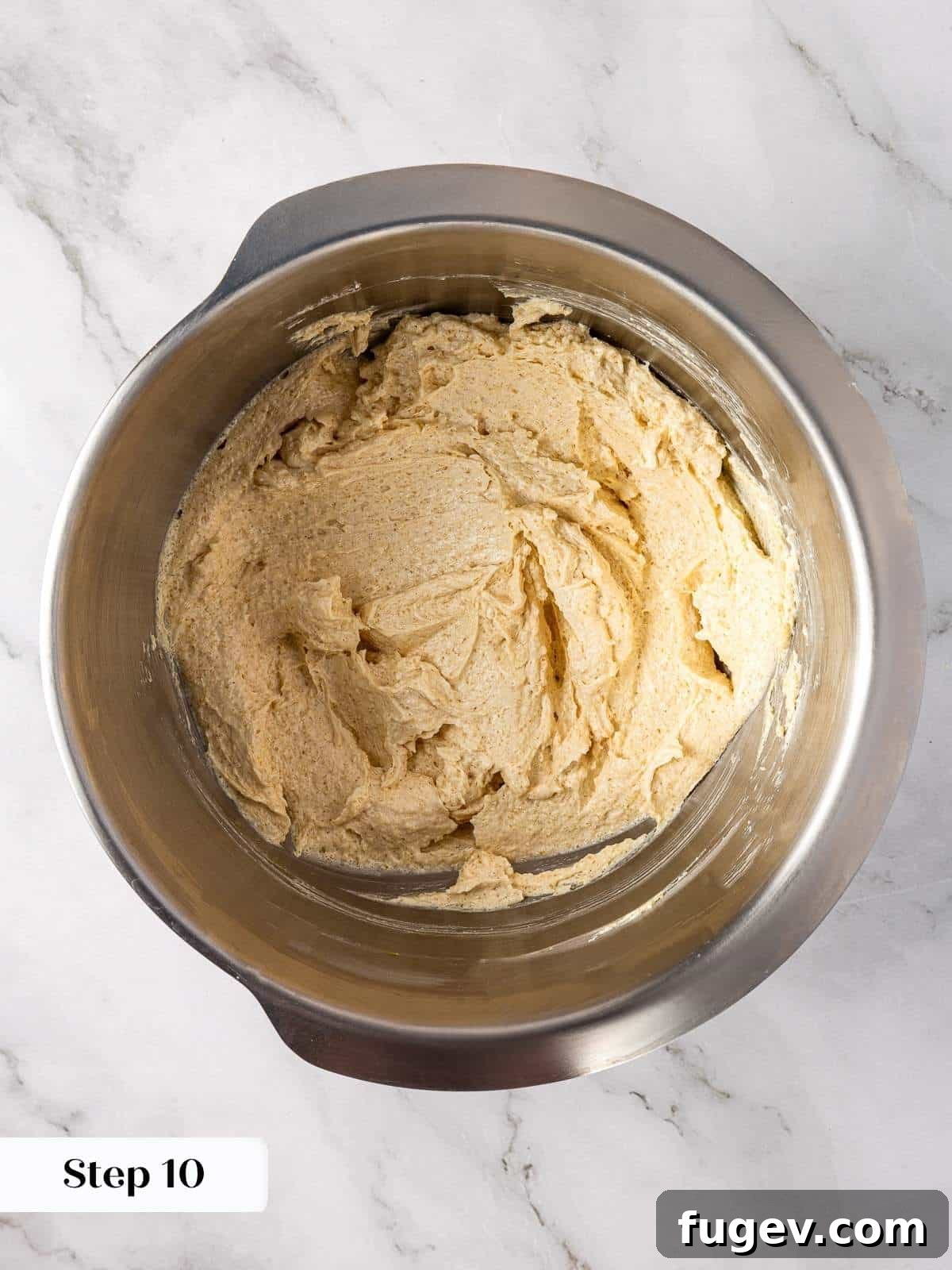 Warm Apple Spice Cookies 9 Mixing bowl with a single egg and vanilla extract being stirred into the rich brown sugar and butter cookie base, creating a lighter, emulsified mixture.