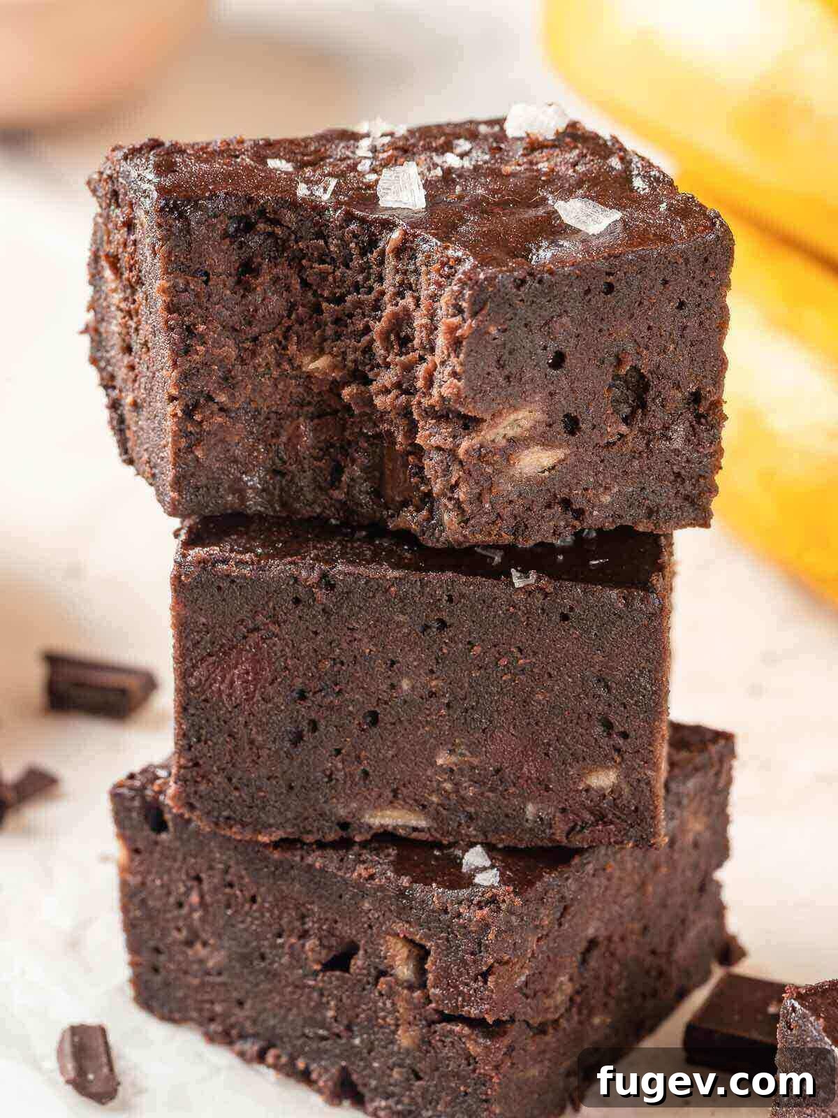 Fudgy Banana Brownies 2 A stack of three intensely fudgy banana brownies, showcasing their rich chocolate color and delicious texture.