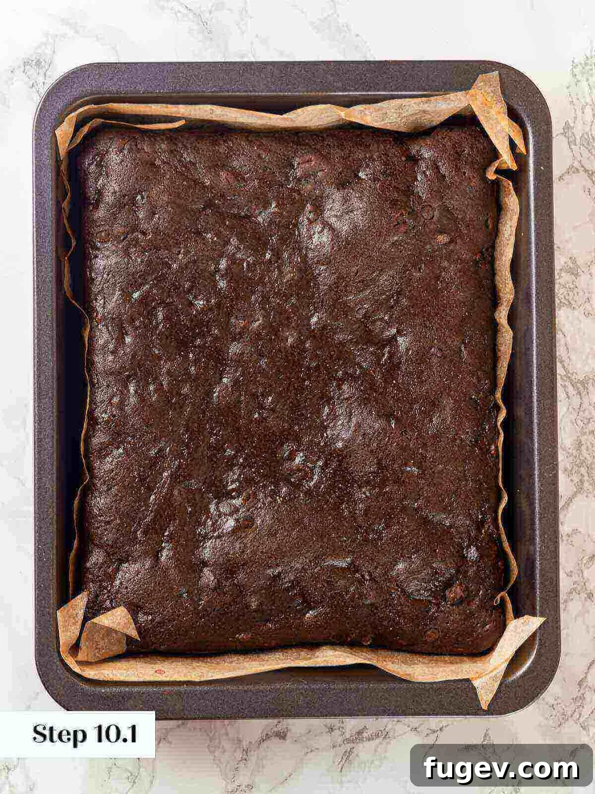 Fudgy Banana Brownies 11 Freshly baked banana brownies cooling in a pan, showing their shiny, crinkly top.