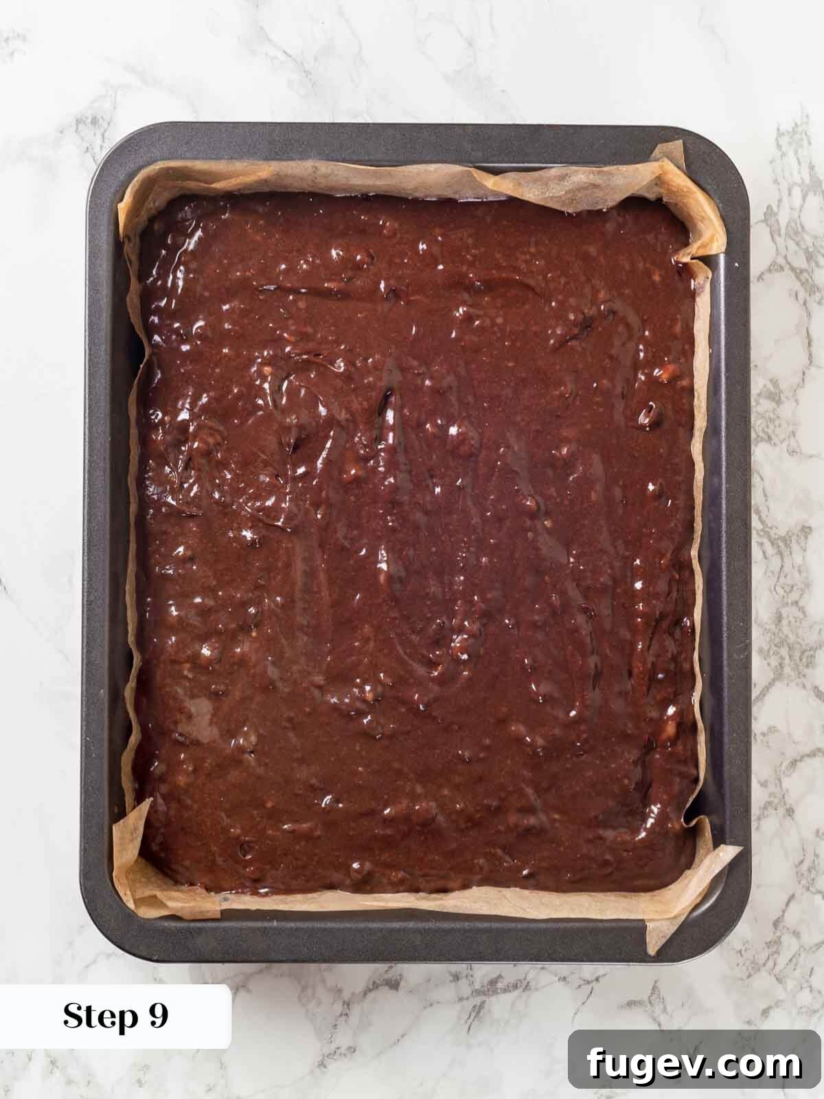 Fudgy Banana Brownies 10 Unbaked banana brownie batter, studded with chocolate chips, spread evenly in a parchment-lined baking pan.