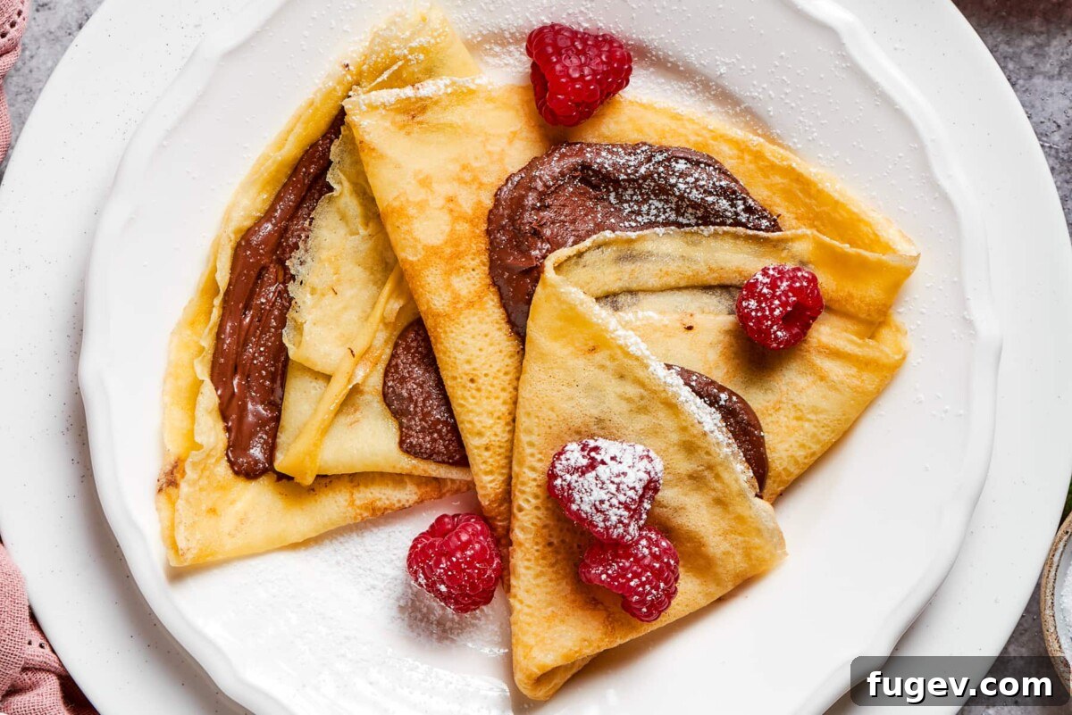 Easy Sweet Crepe Perfection 5 Assorted crepes presented beautifully on a platter, showcasing a variety of sweet and savory fillings, including fresh berries and chocolate.