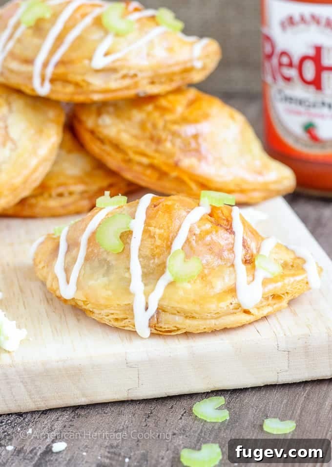 Spicy Buffalo Blue Cheese Pockets 2 Golden brown Buffalo Chicken Blue Cheese Hand Pies, fresh from the oven, showcasing their flaky crust and promising a delicious filling.