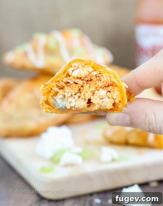 Spicy Buffalo Blue Cheese Pockets 5 Several Buffalo Chicken Blue Cheese Hand Pies on a rustic wooden board, ready for serving with dipping sauce.