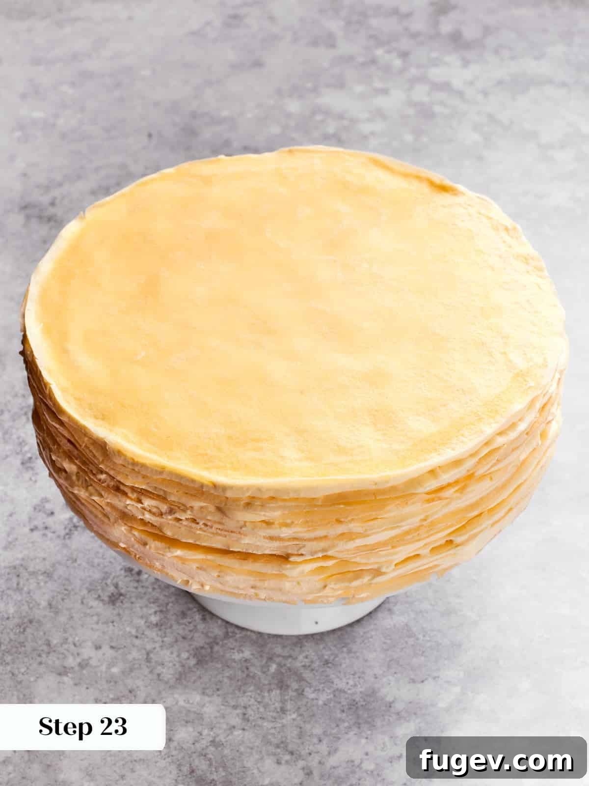 Silken Layered Crepe Delight 15 Crepes being layered with crème légère to build the tall mille crepe cake.