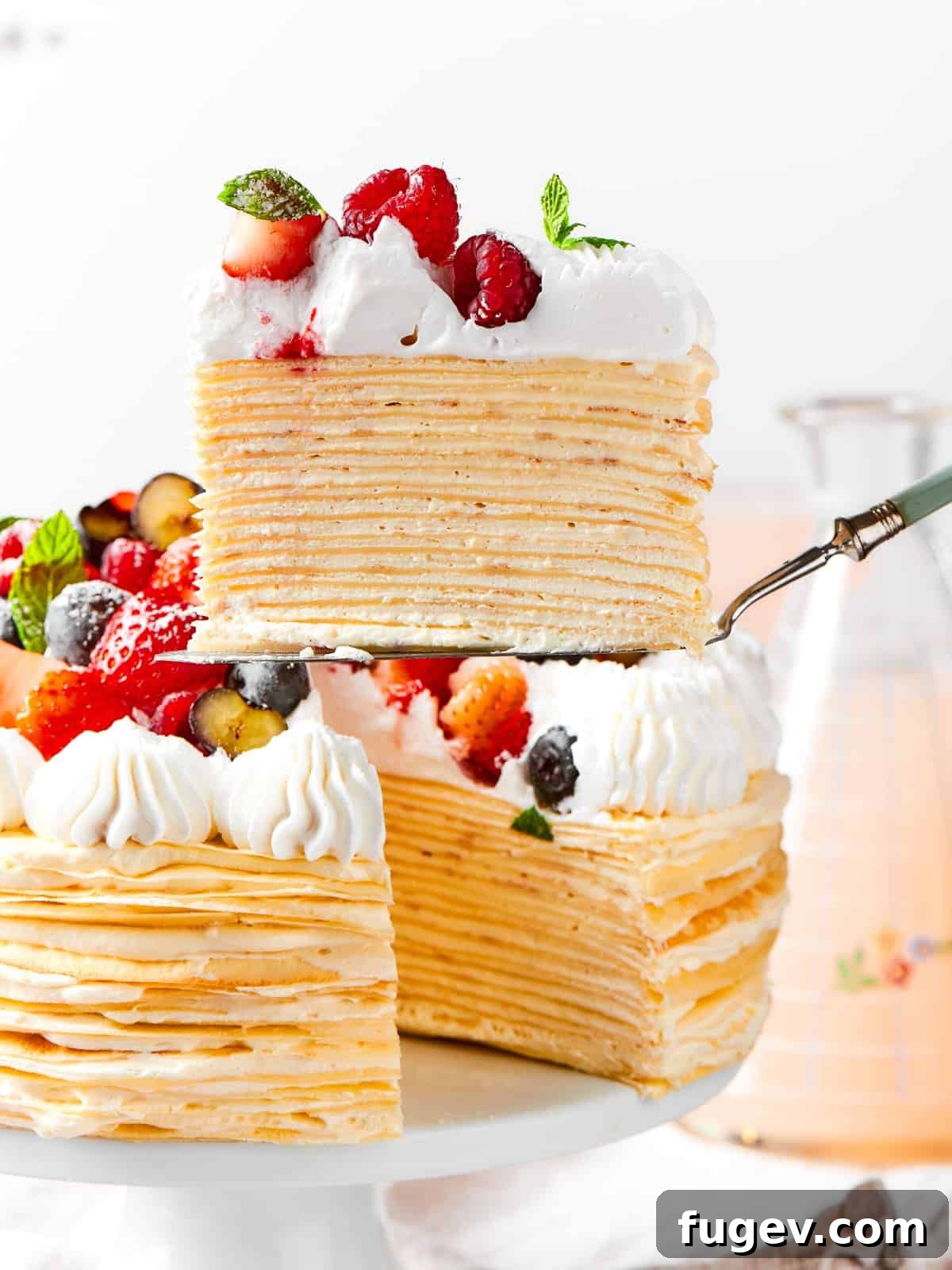 Silken Layered Crepe Delight 17 The cake reveals its layered crepes and vanilla cream after a slice has been taken out.