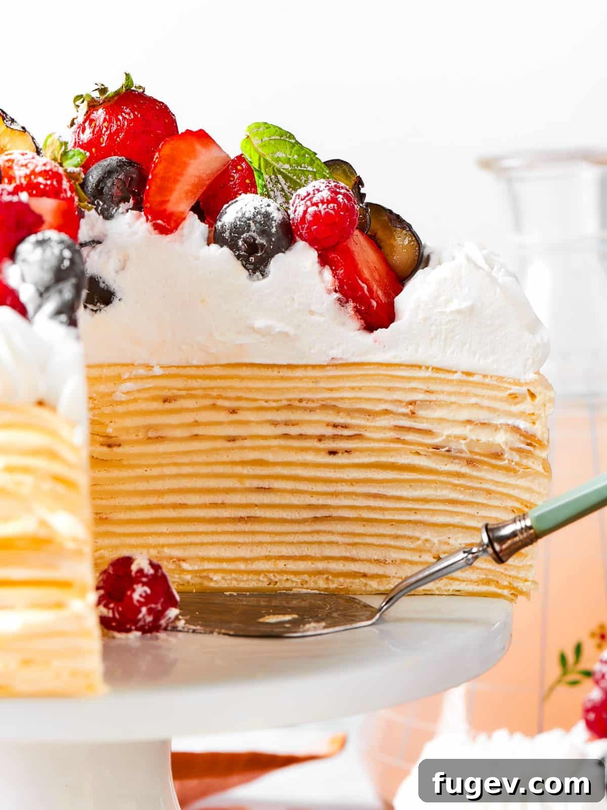Silken Layered Crepe Delight 18 A cake server sliding under a slice of layered crepe cake filled with vanilla cream.