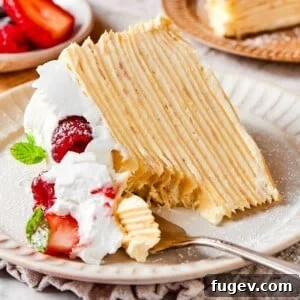 Silken Layered Crepe Delight 19 A lifted bite of crepe cake featuring soft creamy layers and a smooth vanilla texture.