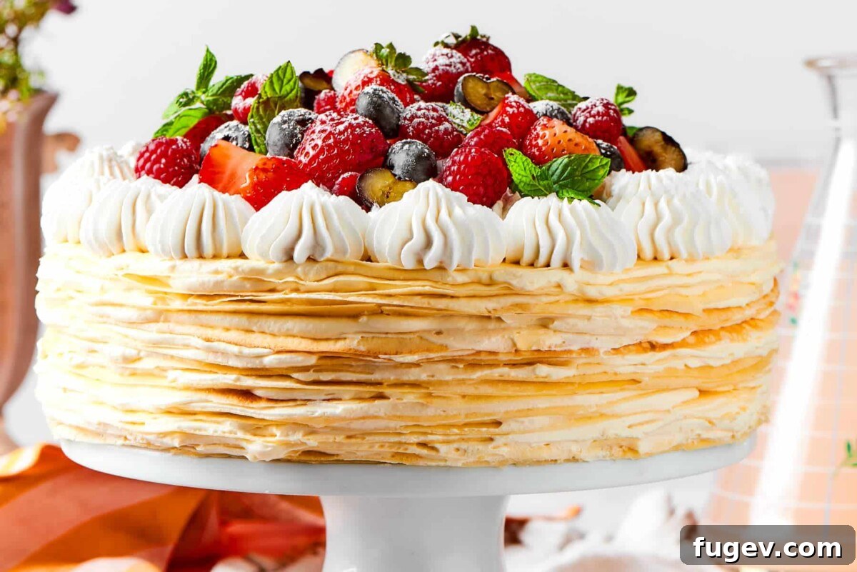 Silken Layered Crepe Delight 5 A full crepe cake decorated with fruit and creamy topping ready for the table.
