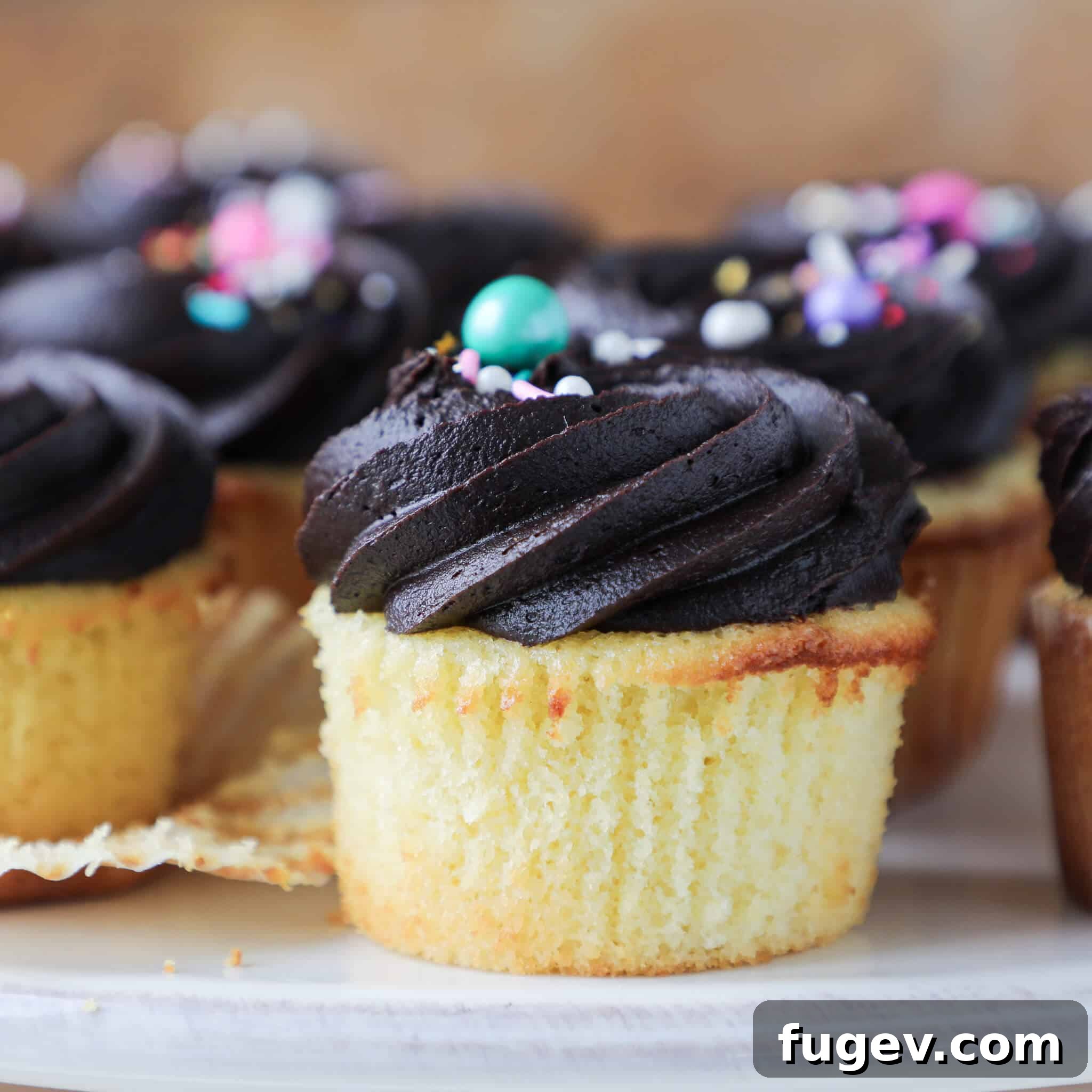 Sunny Yellow Cupcakes with Velvety Chocolate Frosting 3 Yellow Cupcakes with Chocolate frosting liner removed