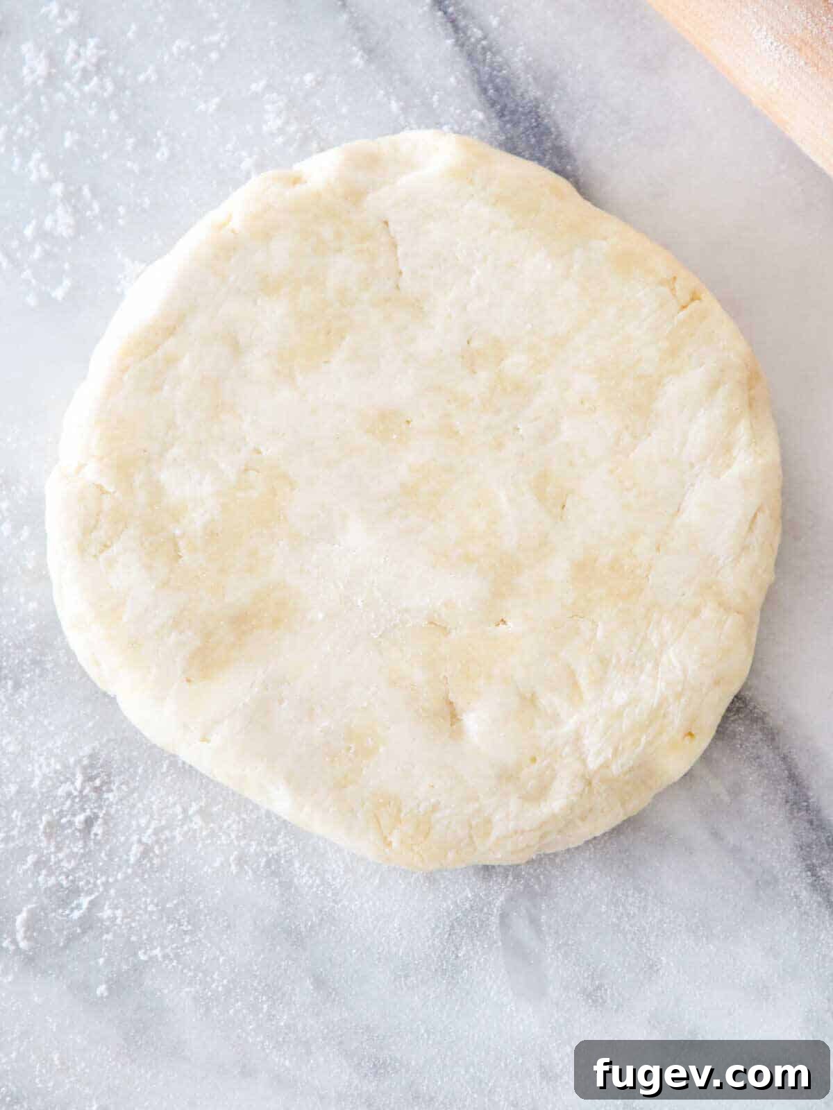 Rich Flaky Butter Pastry 5 Unrolled pie dough on a floured marble surface, ready for shaping.