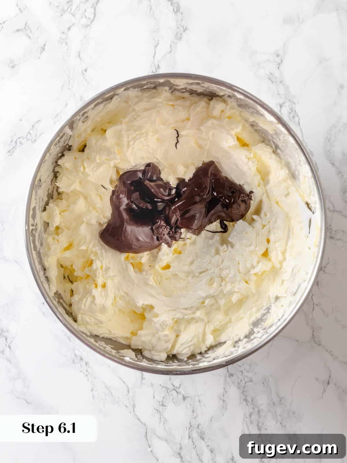 Silky Chocolate Swiss Meringue Buttercream 10 With the buttercream formed, warm melted chocolate is carefully poured into the mixing bowl, signaling the final stage of creating chocolate Swiss meringue buttercream.