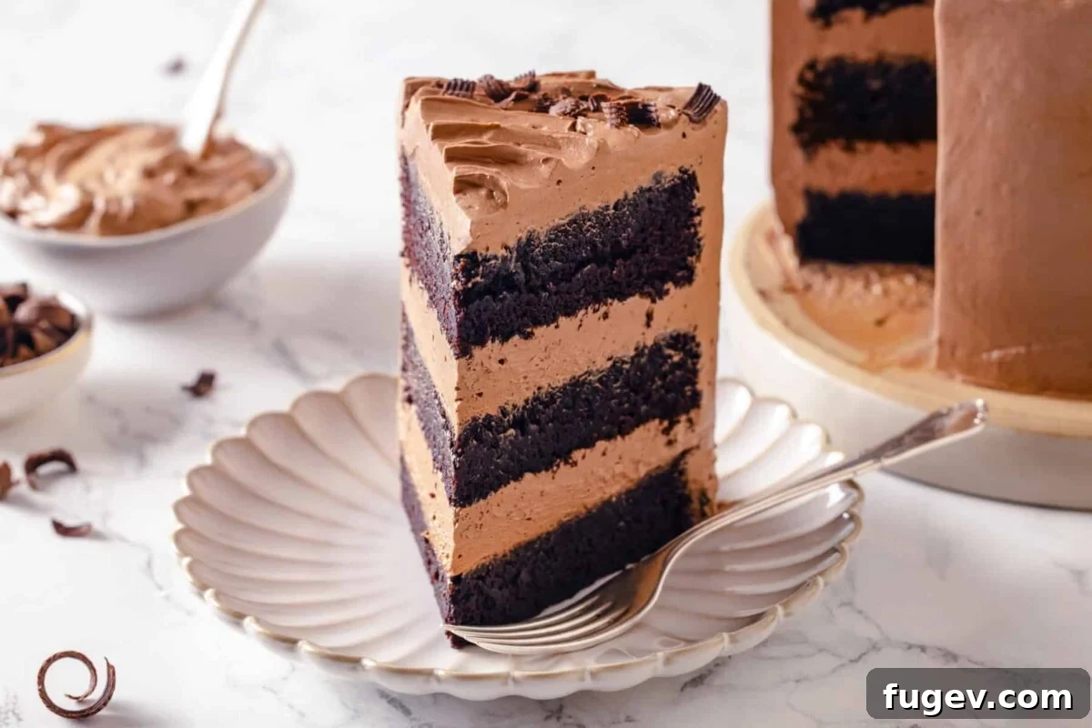 Silky Chocolate Swiss Meringue Buttercream 4 A perfectly layered chocolate cake slice, revealing the smooth and inviting chocolate Swiss meringue buttercream between each moist cake layer.