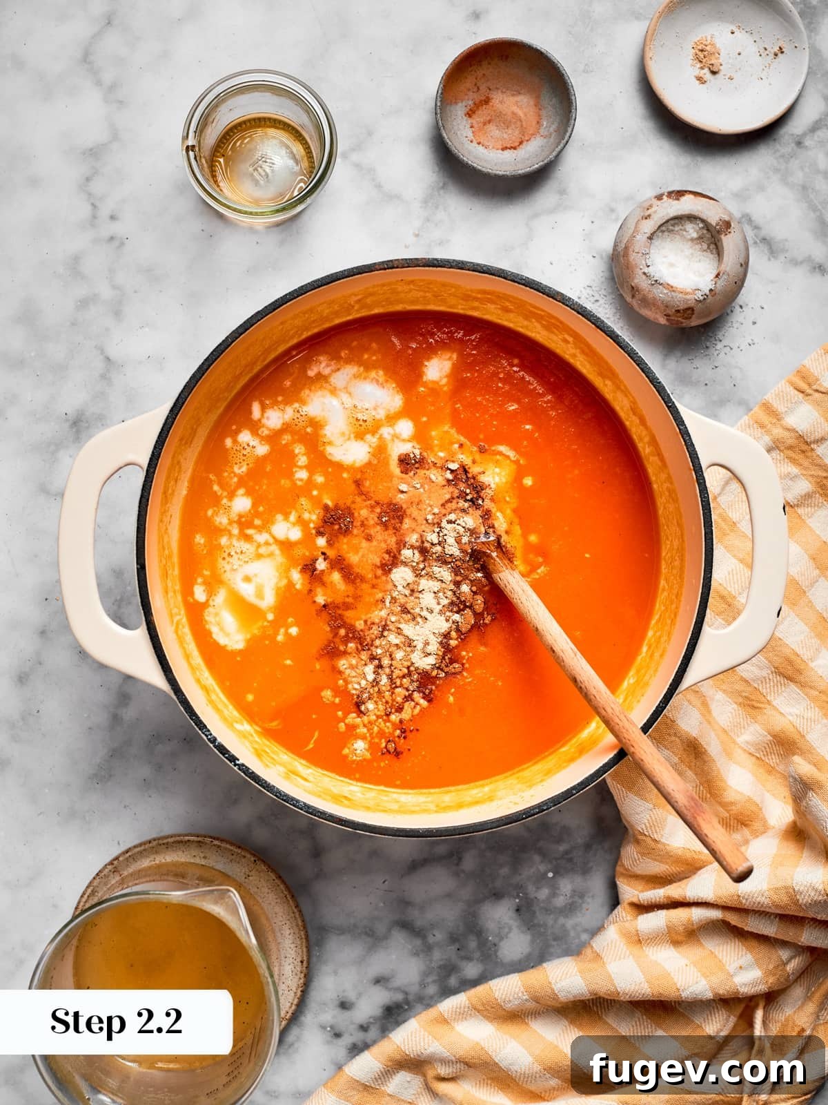 Creamy Vegan Pumpkin Harvest Soup 8 All essential ingredients for pumpkin soup being thoroughly combined in a pot, including pumpkin, stock, spices, coconut cream, and maple syrup, creating a smooth mixture.