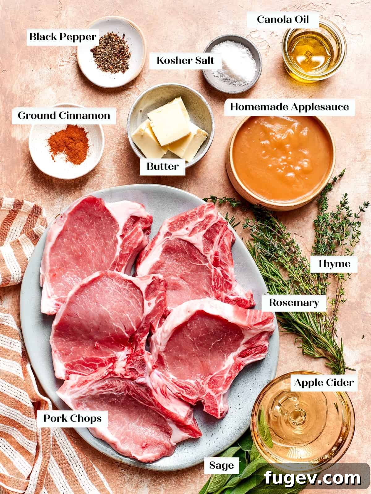 Succulent Pork with Warm Apple Compote 4 Fresh ingredients for pork chops and applesauce recipe, including herbs, apples, and chops, neatly arranged on a kitchen counter.