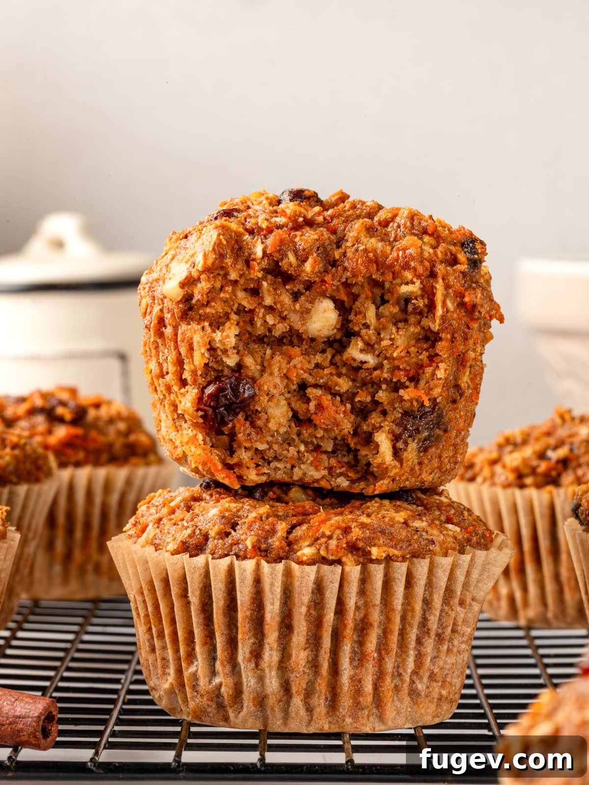 Morning Glow Muffins 2 Bitten morning glory muffin revealing fluffy interior with carrots, oats, and raisins.