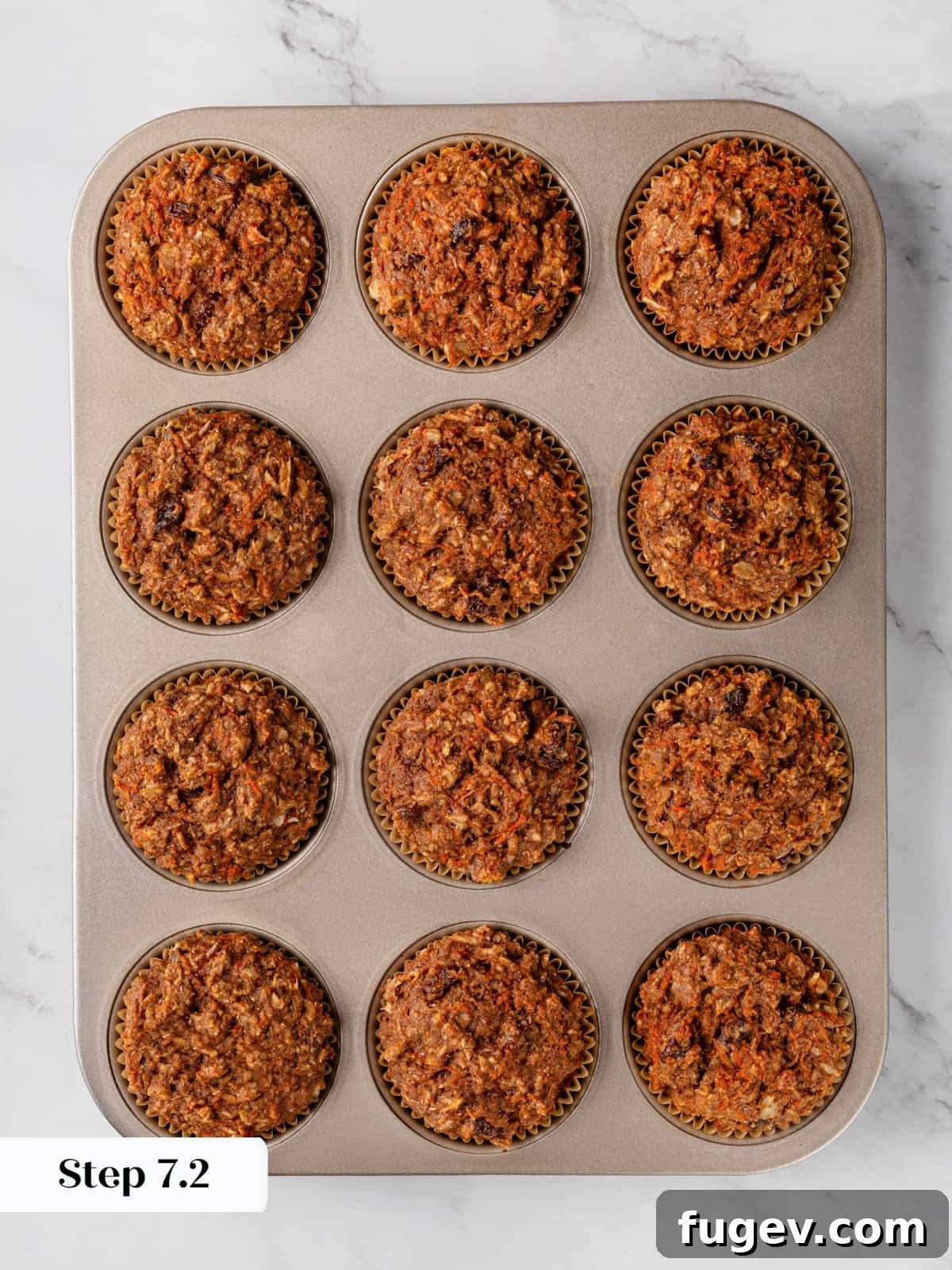 Morning Glow Muffins 12 Golden morning glory muffins baked in a muffin pan and ready to cool.