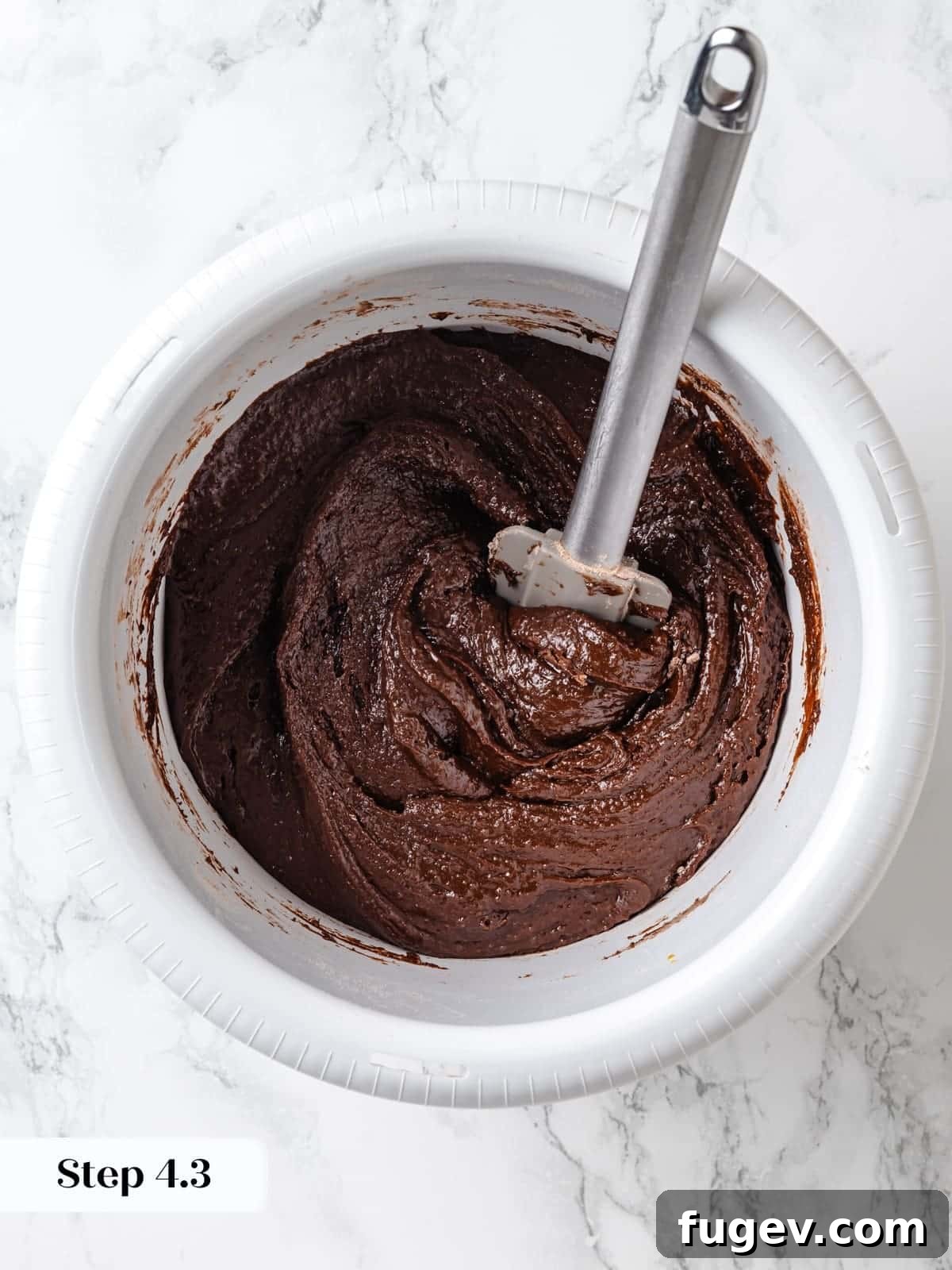 Velvet Chocolate Cherry Indulgence 12 Dry ingredients being gently folded into the wet chocolate cake batter with a silicone spatula until no dry lumps remain.