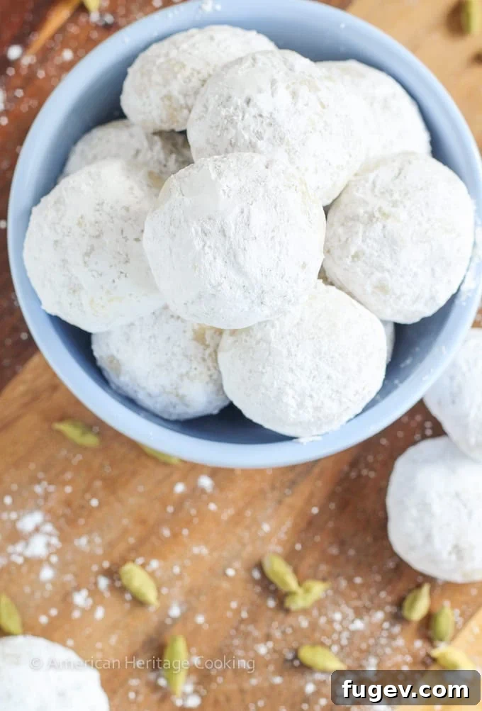 Fragrant Cardamom Walnut Snowdrifts 3 Close-up of freshly baked Cardamom Walnut Snowballs, perfectly round and generously dusted with powdered sugar.