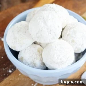 Perfectly baked Cardamom Walnut Snowballs dusted with powdered sugar, ready to be enjoyed.