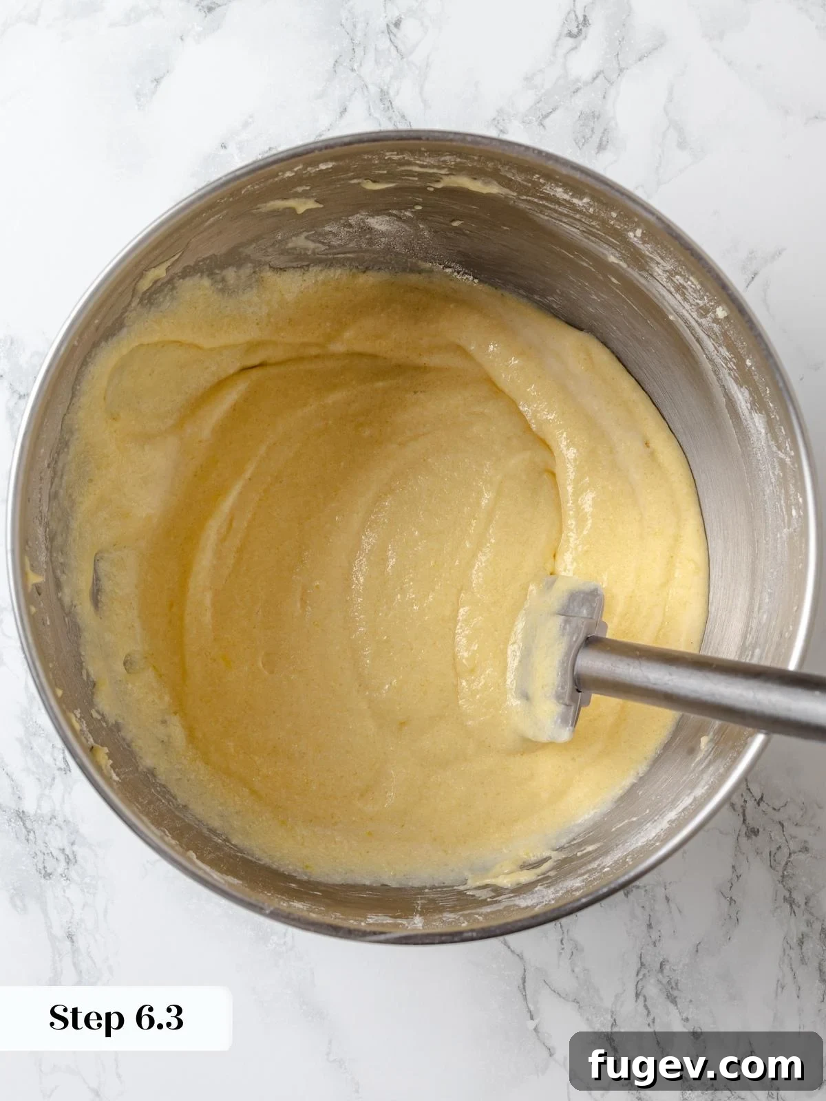 The finished lemon cake batter, smooth, pale, and perfectly textured, ready to be poured into pans for baking.