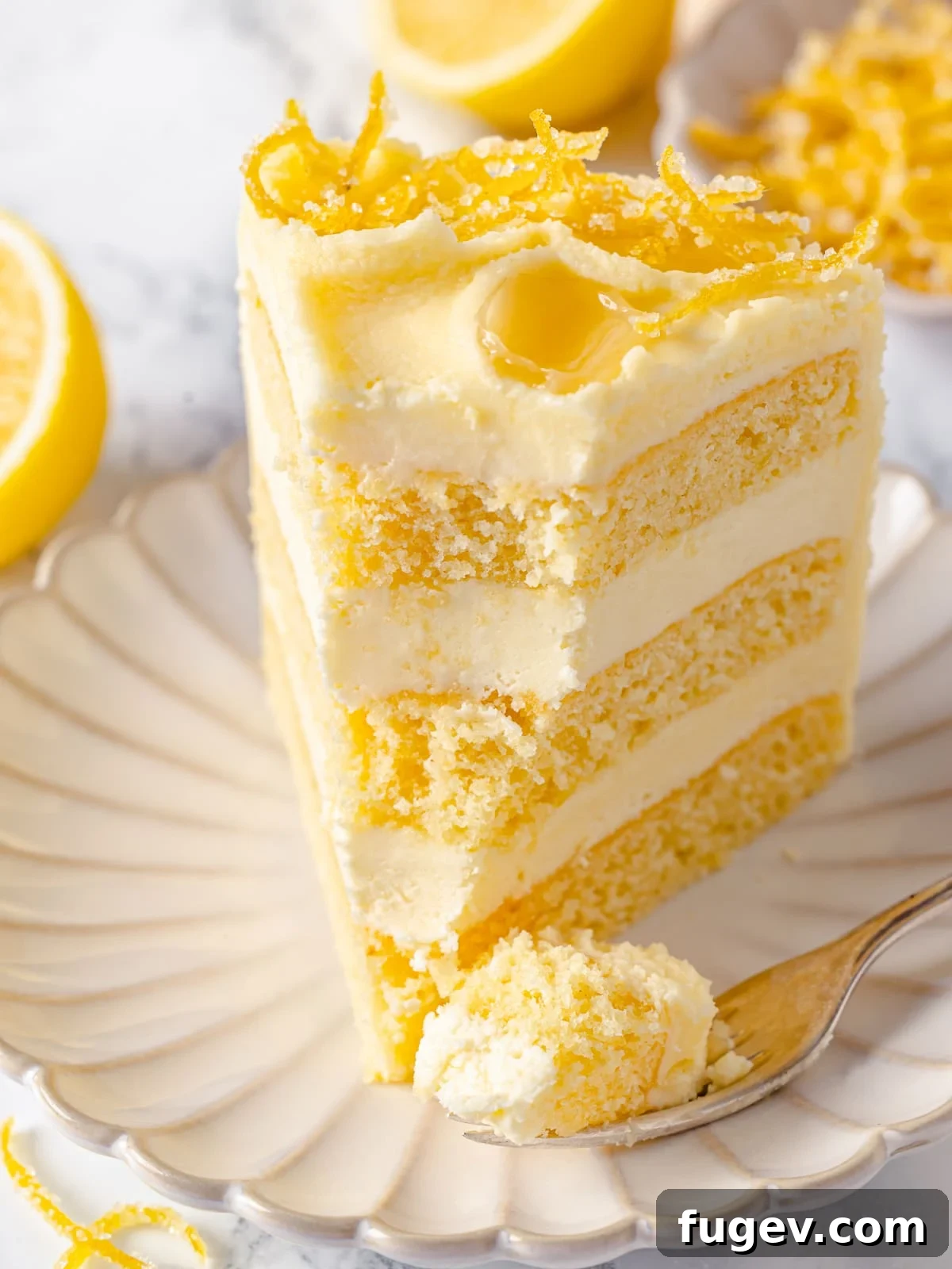 A fork holds a tantalizing bite of lemon cake, showing off its fluffy crumb and generous layer of creamy frosting, ready to be enjoyed.