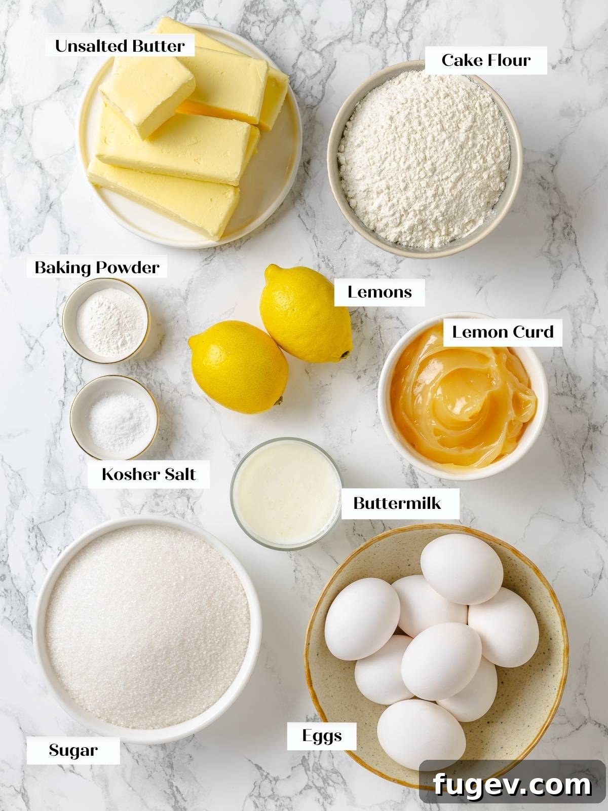 All measured lemon cake ingredients, including butter, flour, sugar, and fresh lemons, neatly arranged on a countertop, ready for mixing.