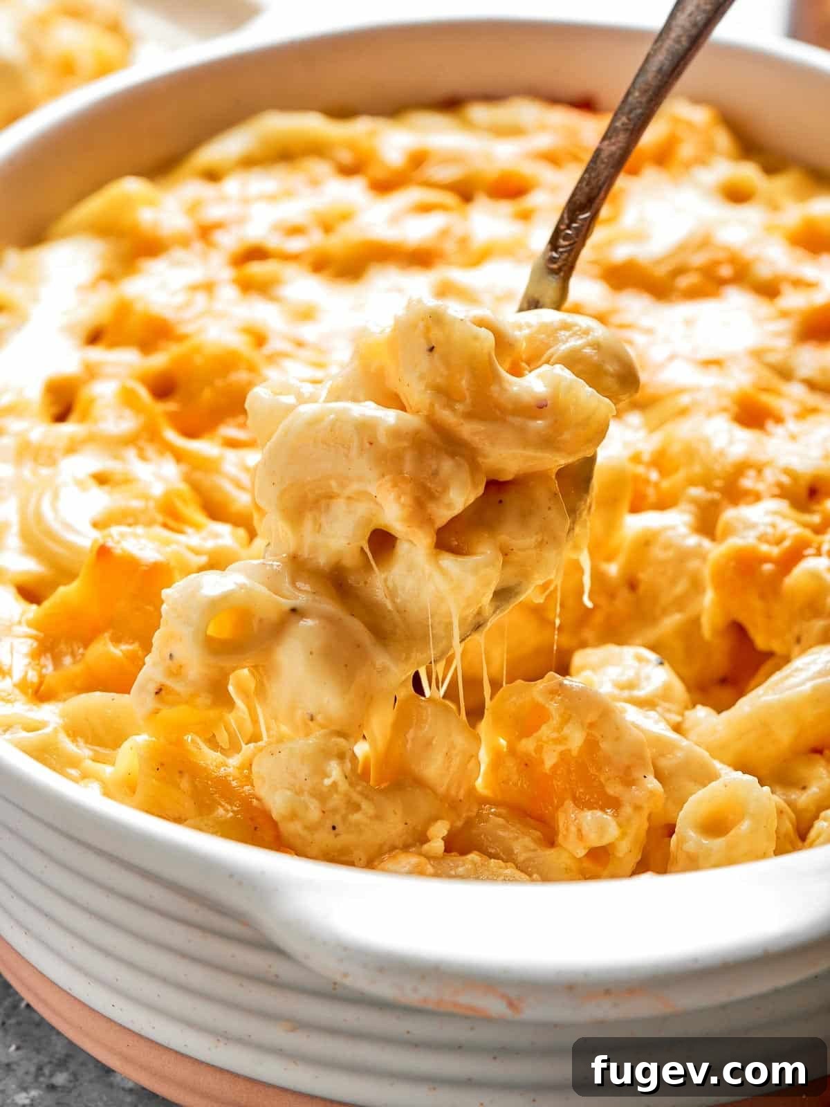 Golden Crusted Baked Mac and Cheese 2 A deep casserole dish overflowing with golden-brown, bubbly baked mac and cheese, ready to be served.