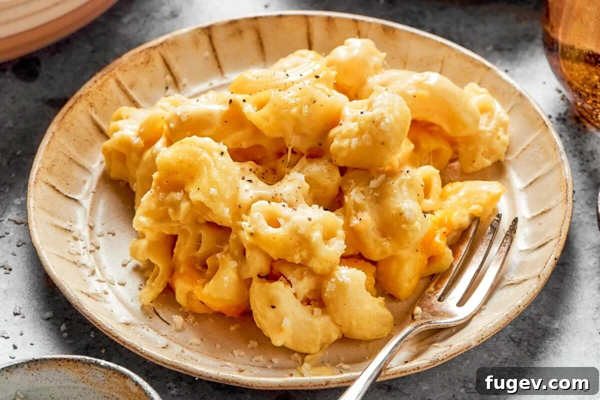 Golden Crusted Baked Mac and Cheese 3 A generous serving of creamy, golden baked mac and cheese being scooped directly from the casserole dish, showcasing its perfect texture.