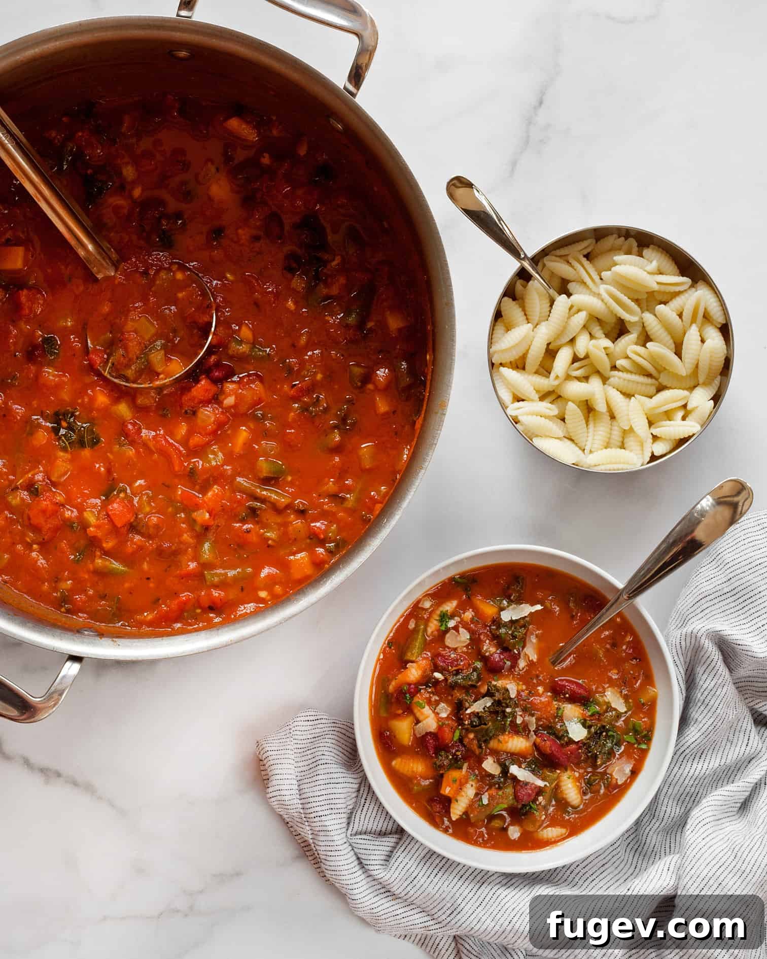 Wholesome Garden Minestrone 6 Separately cooked pasta being added to a bowl of minestrone soup after the soup has finished simmering.