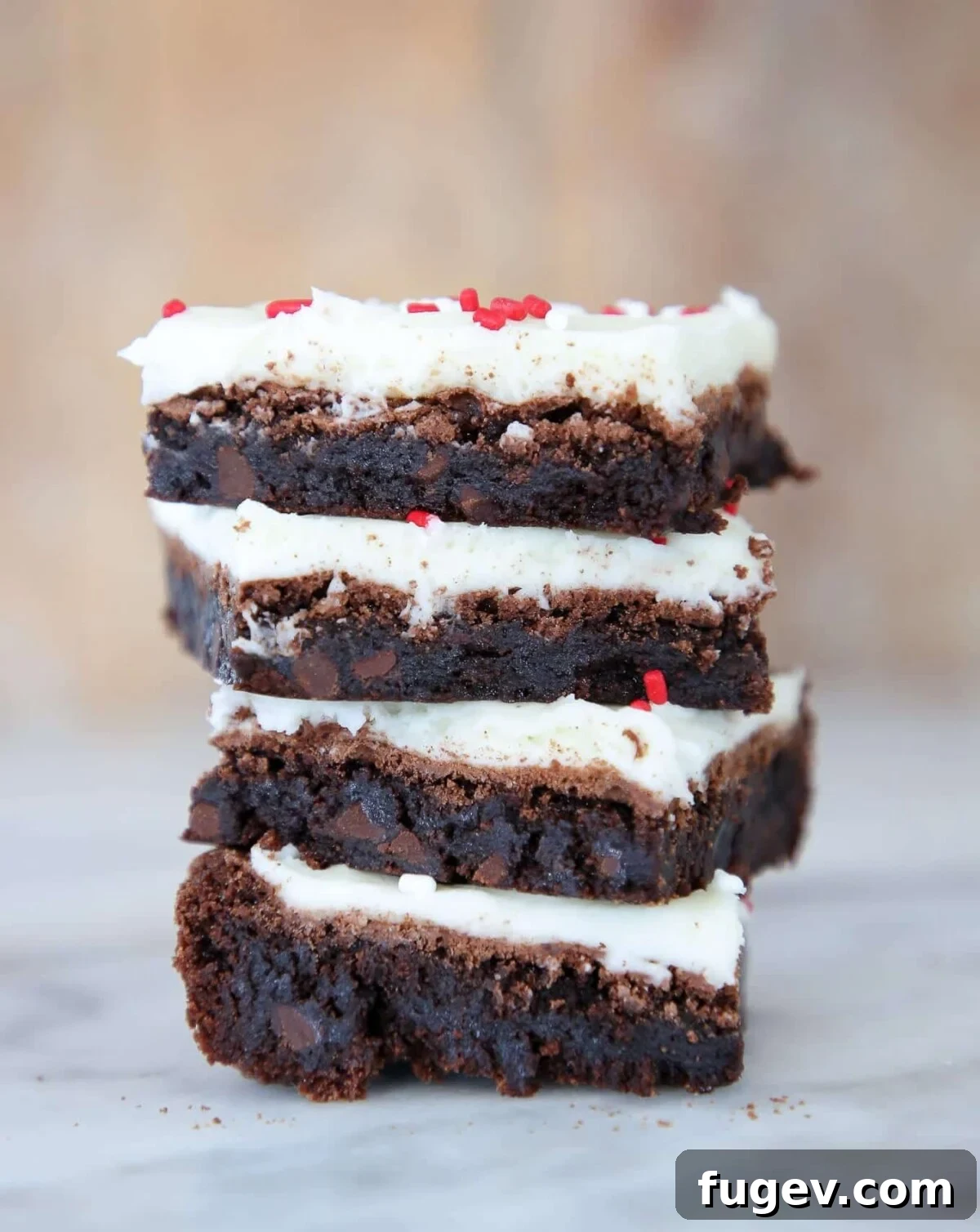 16 Festive Chocolate Christmas Cookies 12 A tempting stack of iced brownies, generously adorned with festive red sprinkles, a perfect chocolate Christmas cookie treat.