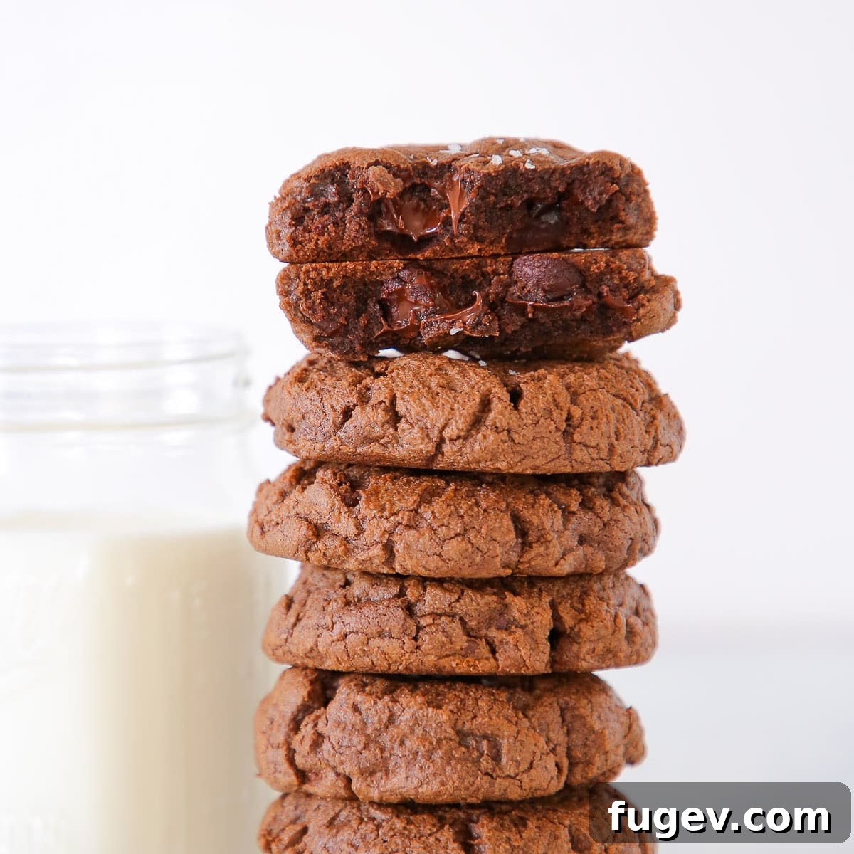 16 Festive Chocolate Christmas Cookies 22 A stack of Triple Chocolate Chip Cookies invitingly placed next to a glass of cold milk, a classic pairing.
