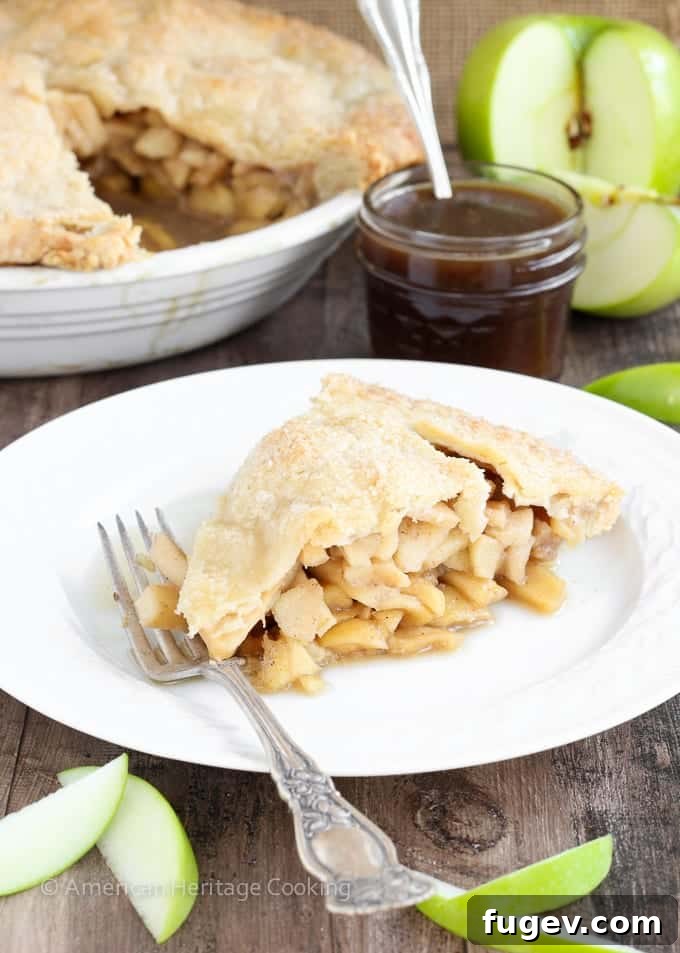 Creamy Butterscotch Apple Tart 6 A perfectly baked Apple Butterscotch Pie, with a slice removed, showing the luscious filling and a swirl of butterscotch on top.