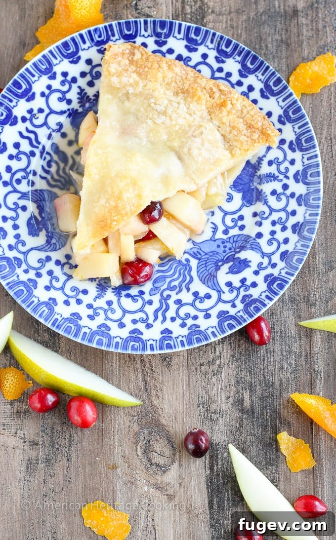 Vibrant Cranberry Orange Pear Pie 3 Close-up of the Cranberry Orange Pear Pie, showing the golden-brown crimped crust and the bubbly, fruit-filled interior.