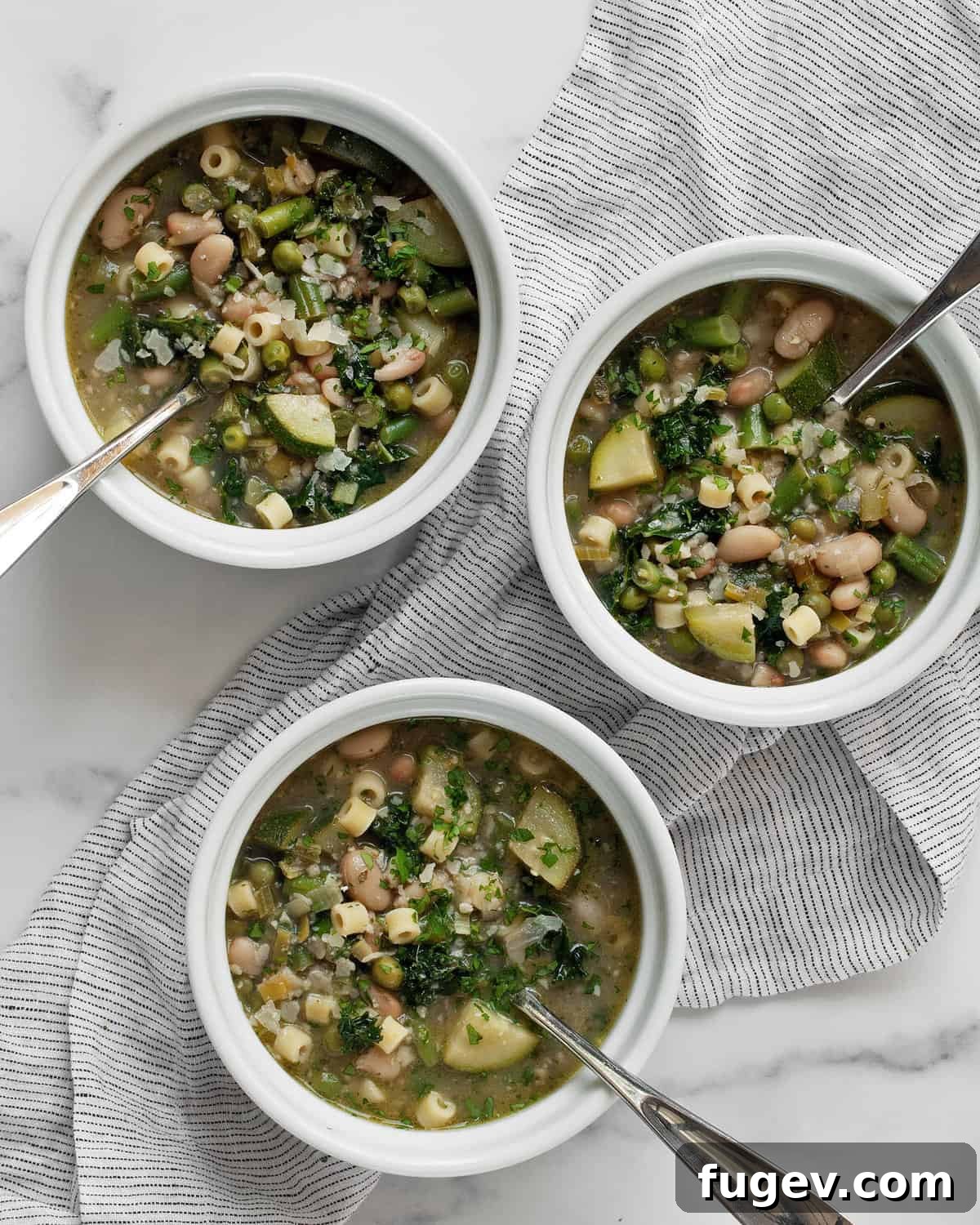 Vibrant Garden Minestrone 7 Three bowls of steaming green minestrone soup, garnished and ready to be enjoyed, showcasing the vibrant colors of the fresh ingredients.