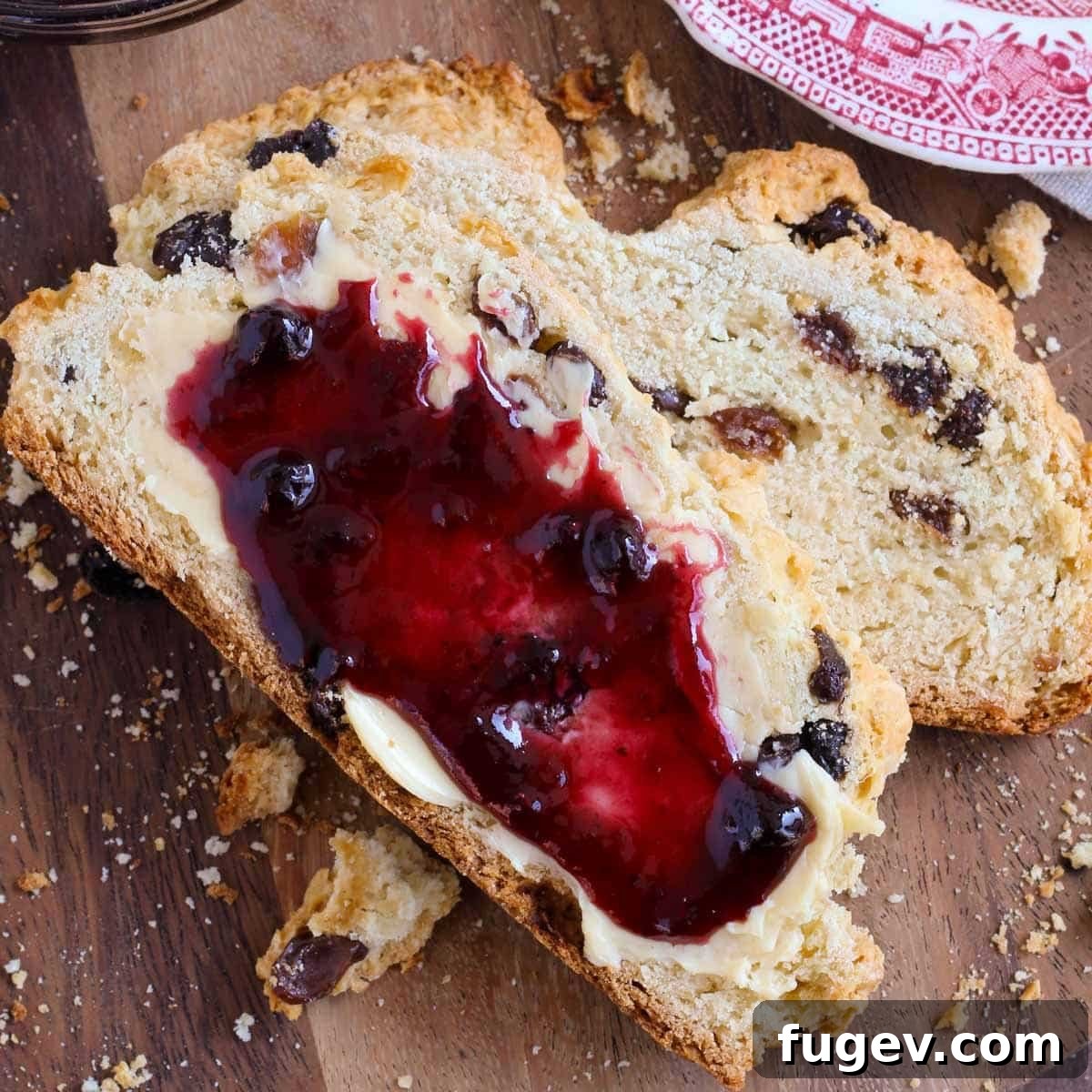 Simple Sweet Irish Raisin Bread 4 Two slices of warm Irish soda bread, one with butter and one with jam, ready to be enjoyed.